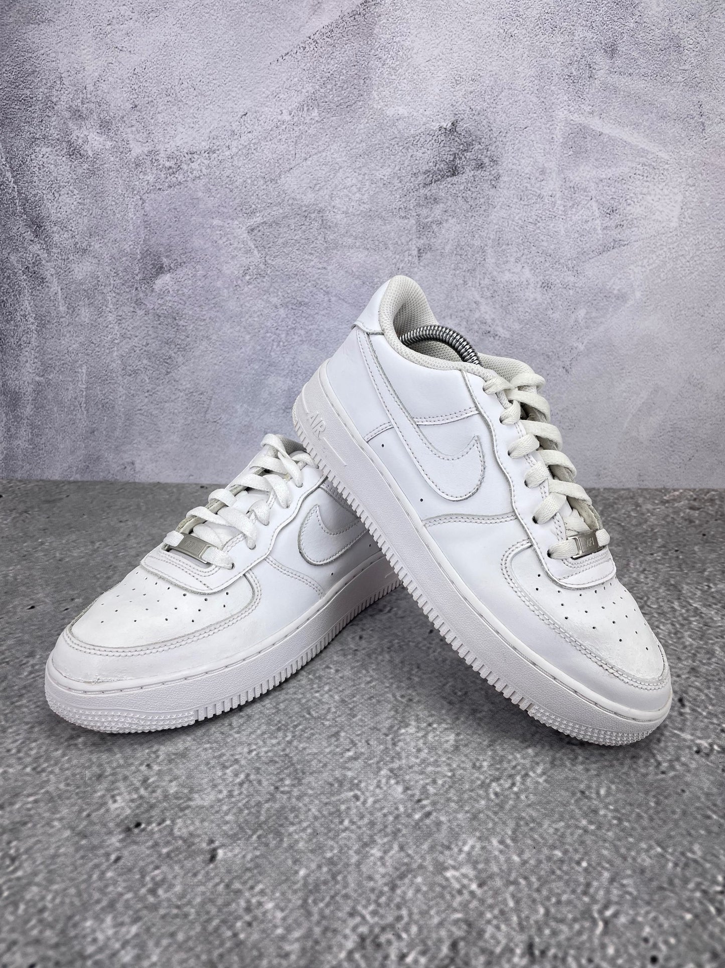 Nike Air Force 1 Low Triple White - buty sportowe, para butów, widok z boku na tle studyjnym