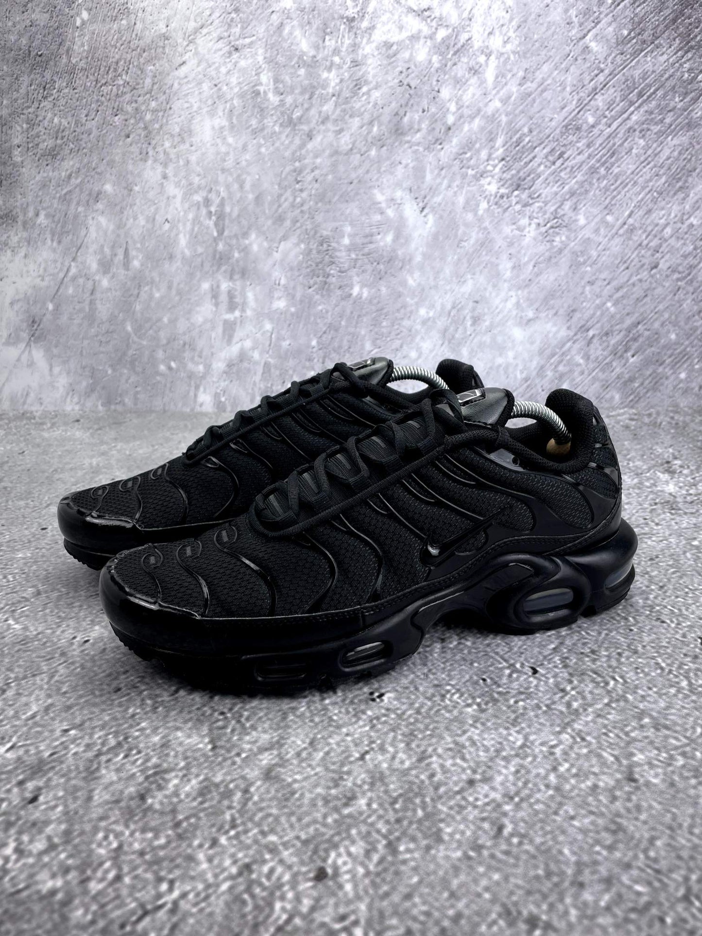Nike Air Max Plus Triple Black - buty sportowe, widok z boku na tle studyjnym