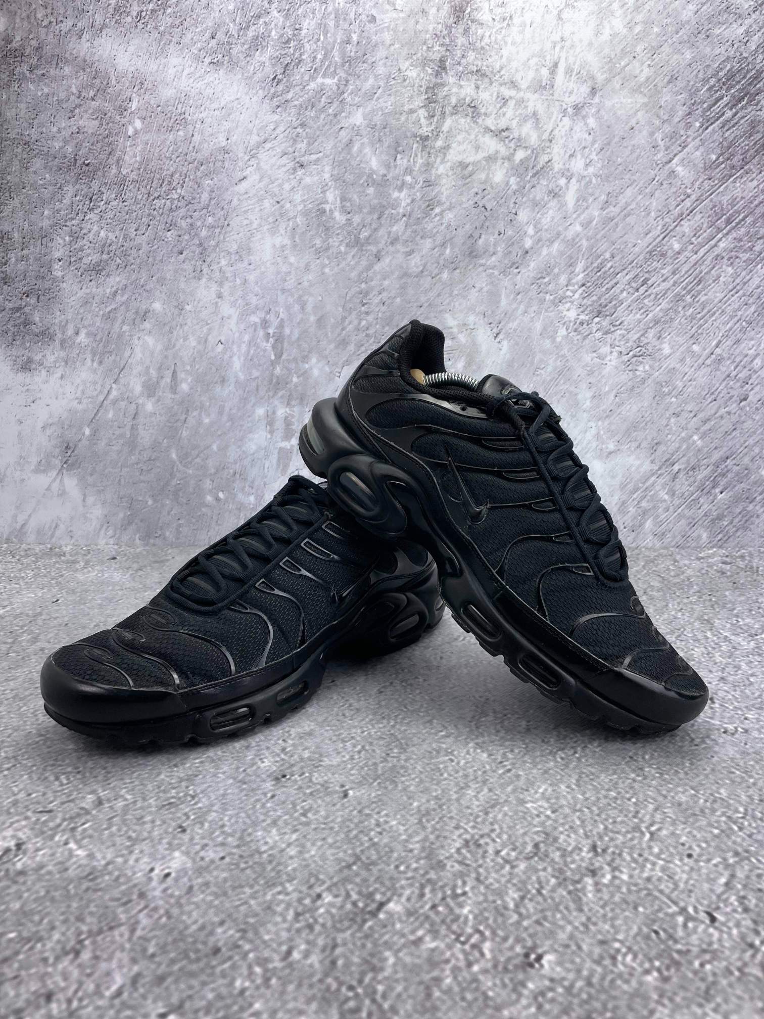 Nike Air Max Plus Triple Black - buty sportowe, para butów, widok z boku na tle studyjnym