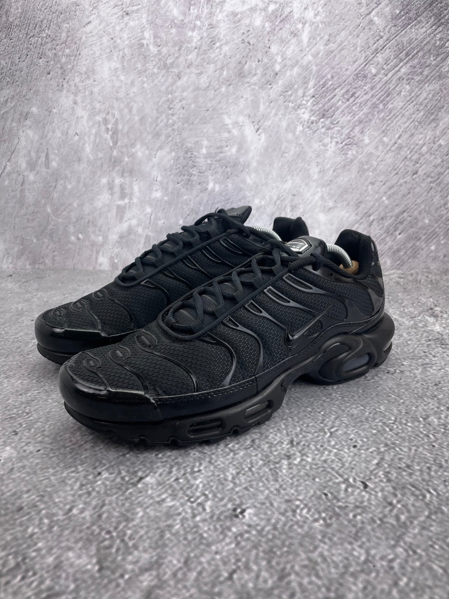 Nike Air Max Plus Triple Black - buty sportowe, widok z boku na tle studyjnym