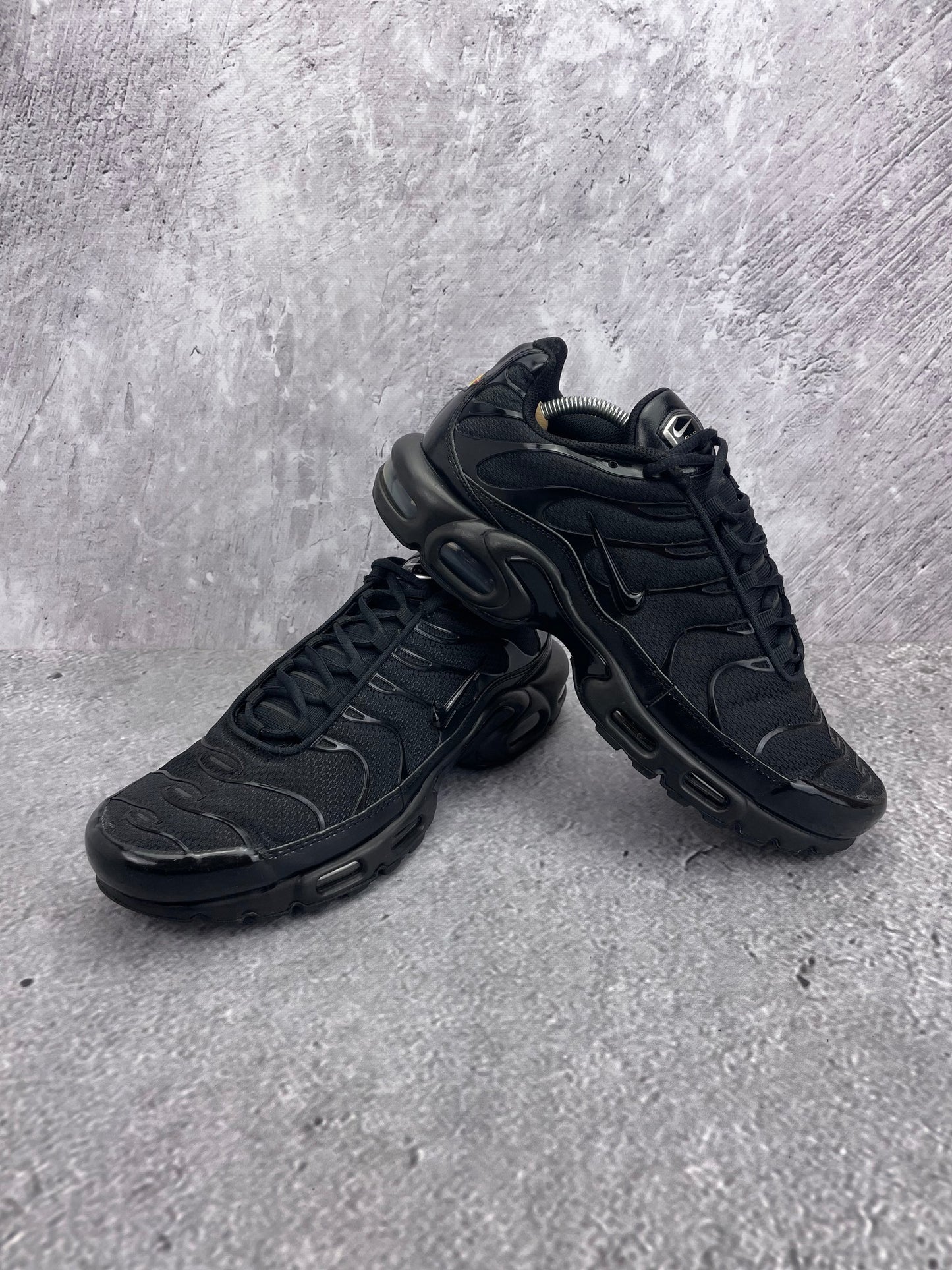 Nike Air Max Plus Triple Black - buty sportowe, para butów, widok z boku na tle studyjnym