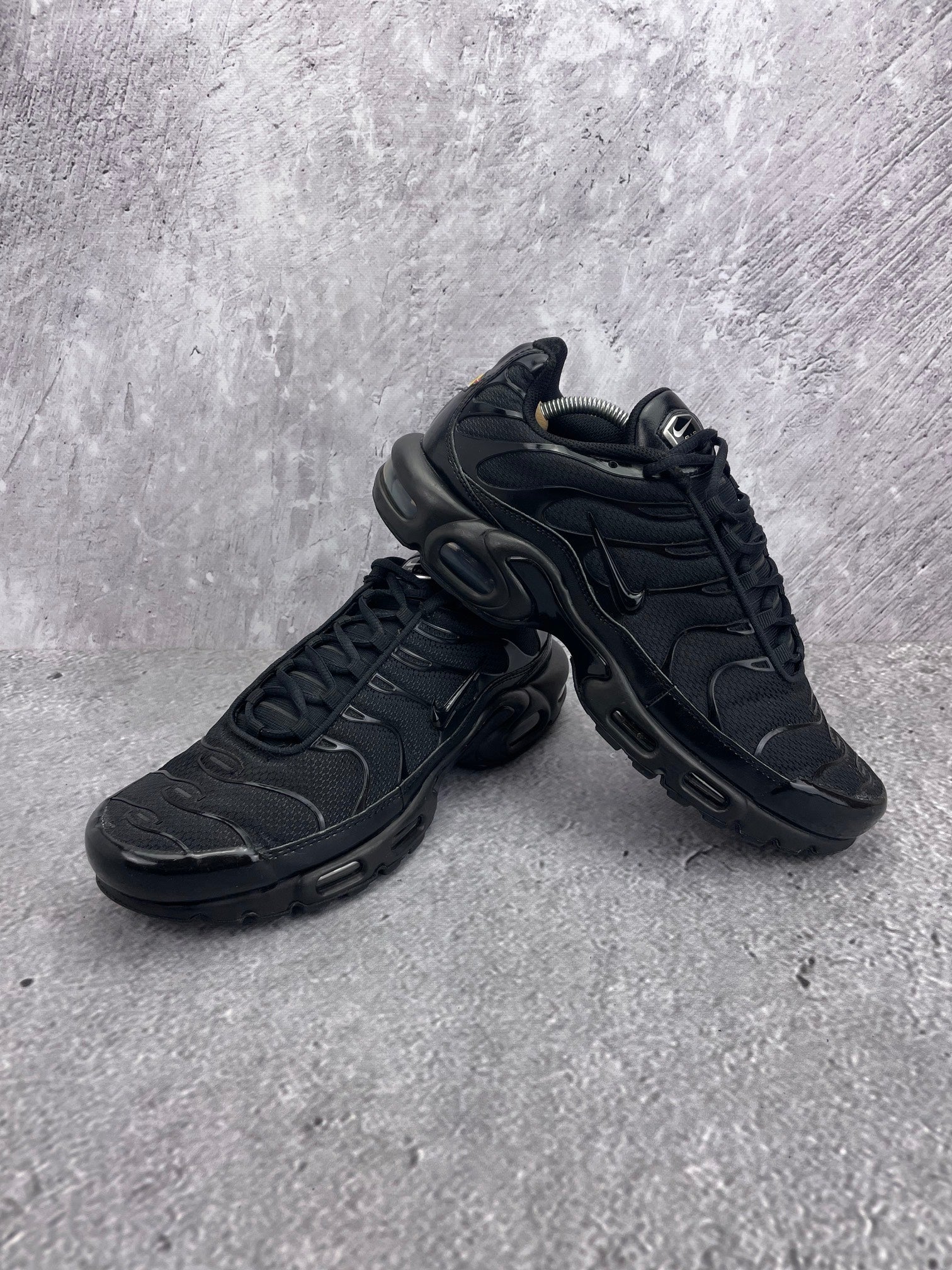 Nike Air Max Plus Triple Black - buty sportowe, para butów, widok z boku na tle studyjnym