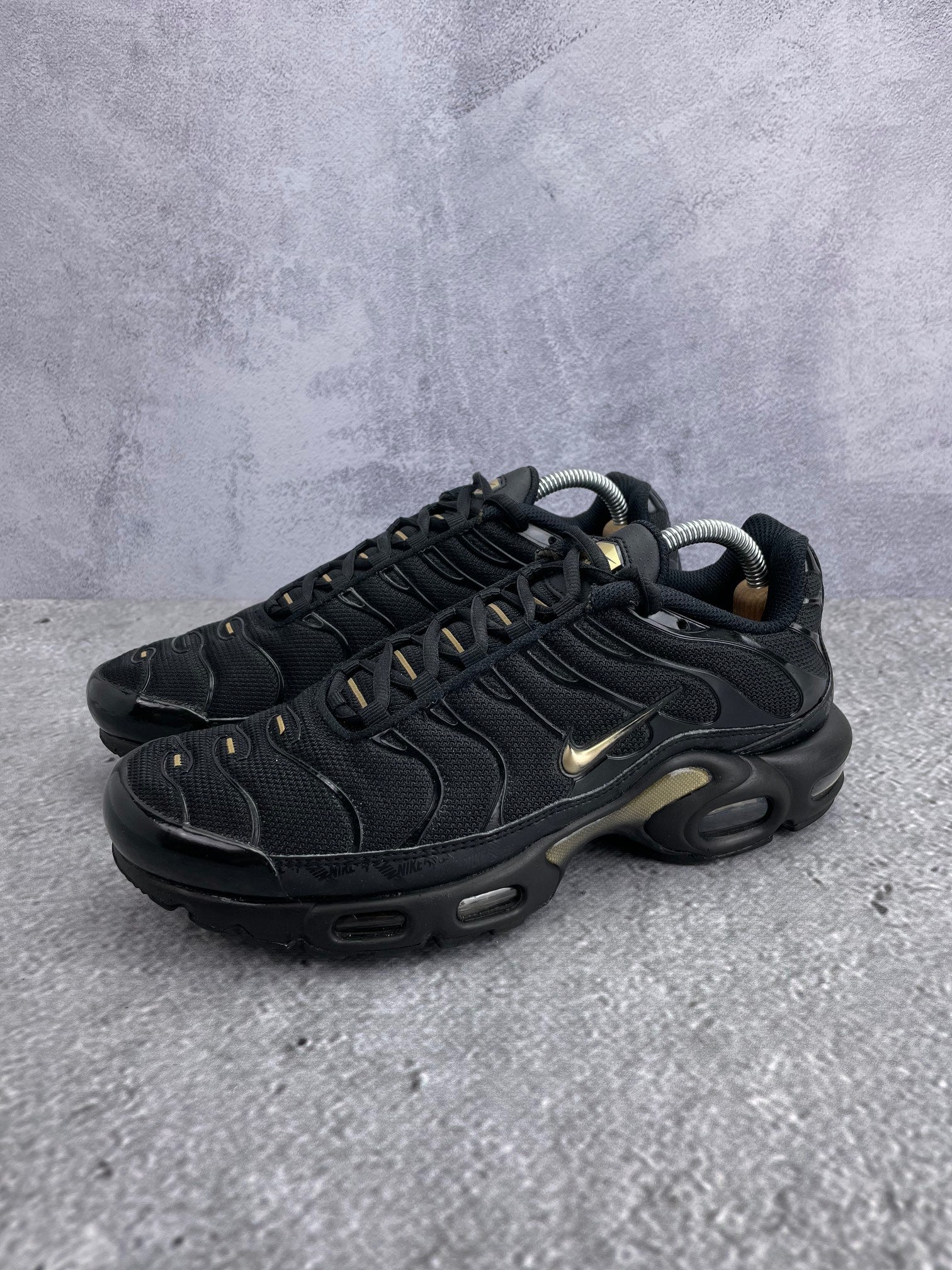 Nike Air Max Plus Black Metallic Gold - buty sportowe, widok z boku na tle studyjnym