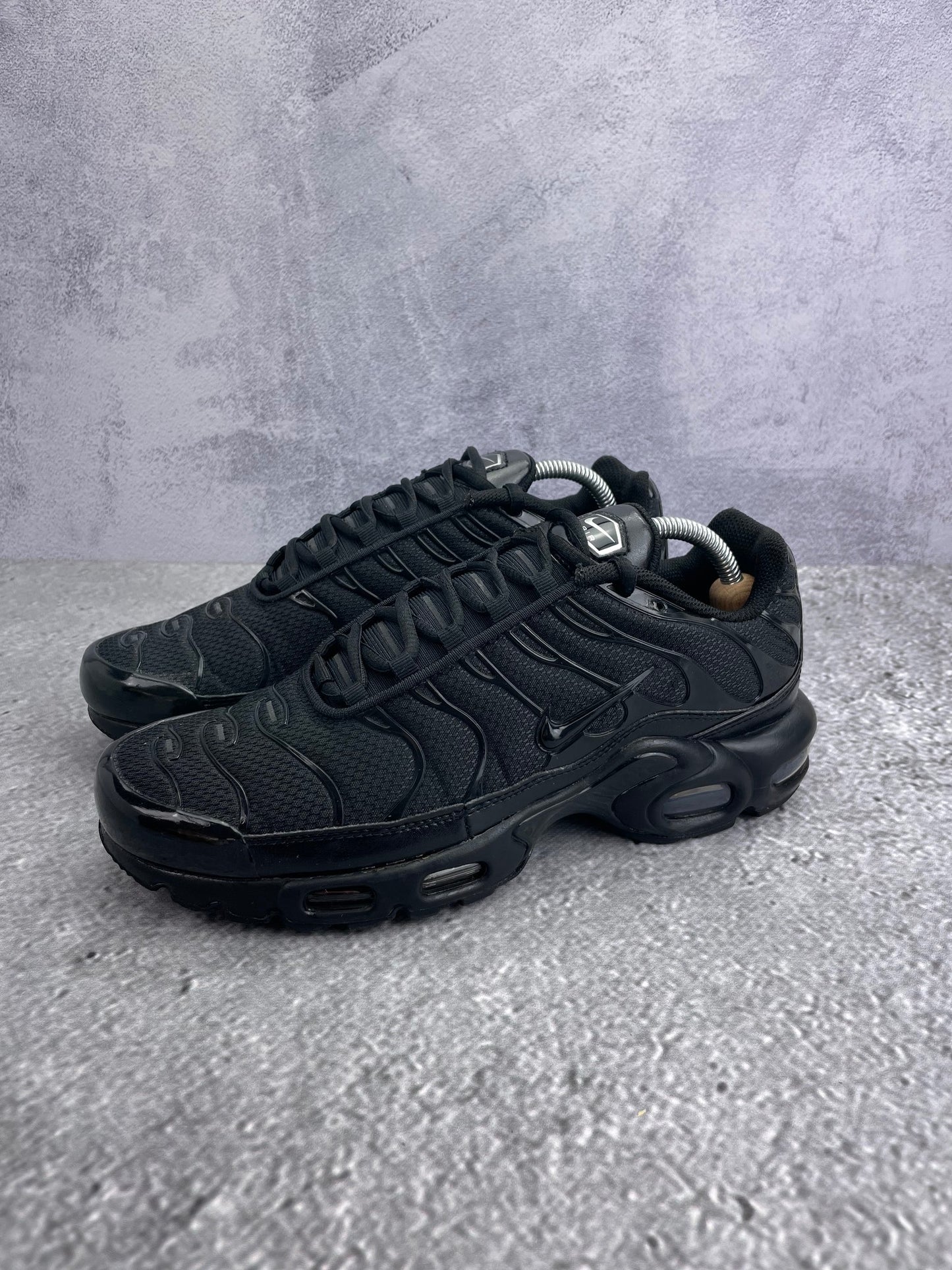 Nike Air Max Plus Triple Black - buty sportowe, widok z boku na tle studyjnym
