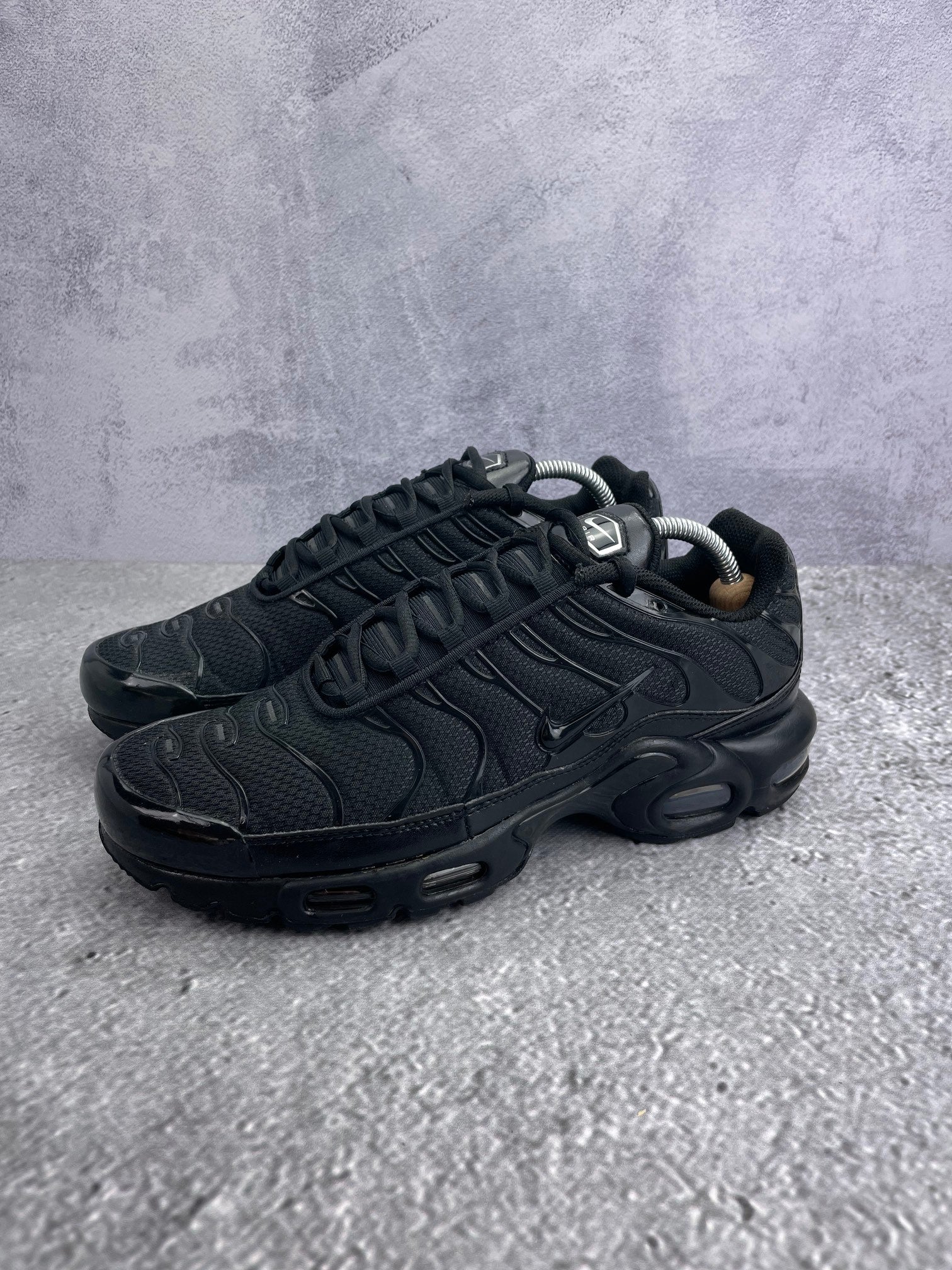 Nike Air Max Plus Triple Black - buty sportowe, widok z boku na tle studyjnym