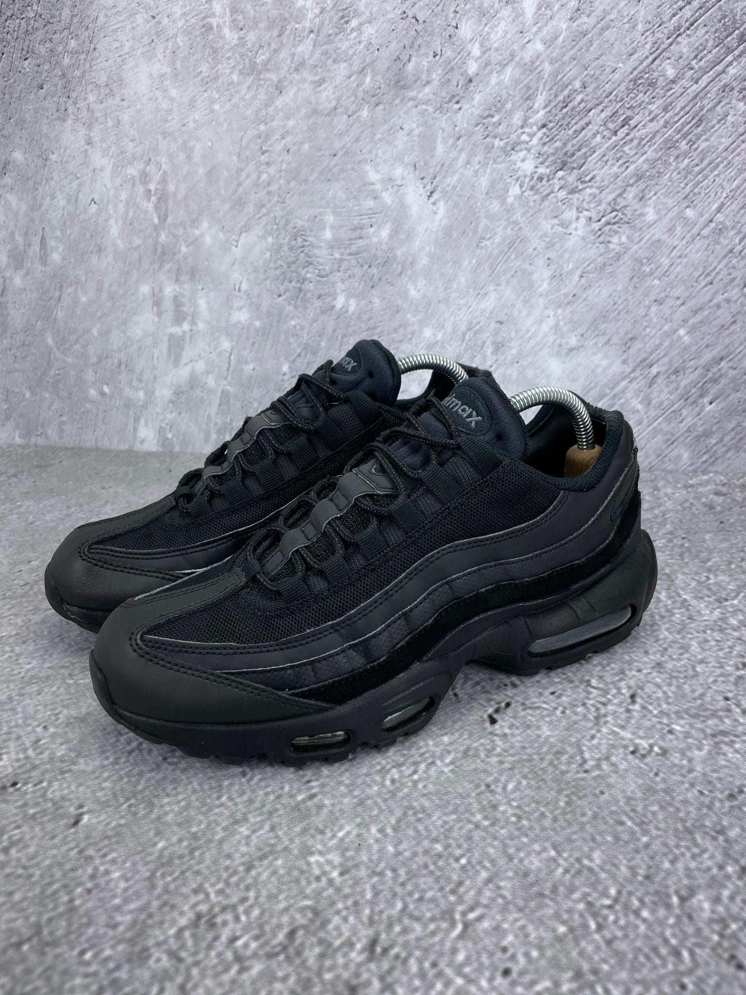 Nike Air Max 95 Essential Triple Black - buty sportowe, widok z boku na tle studyjnym