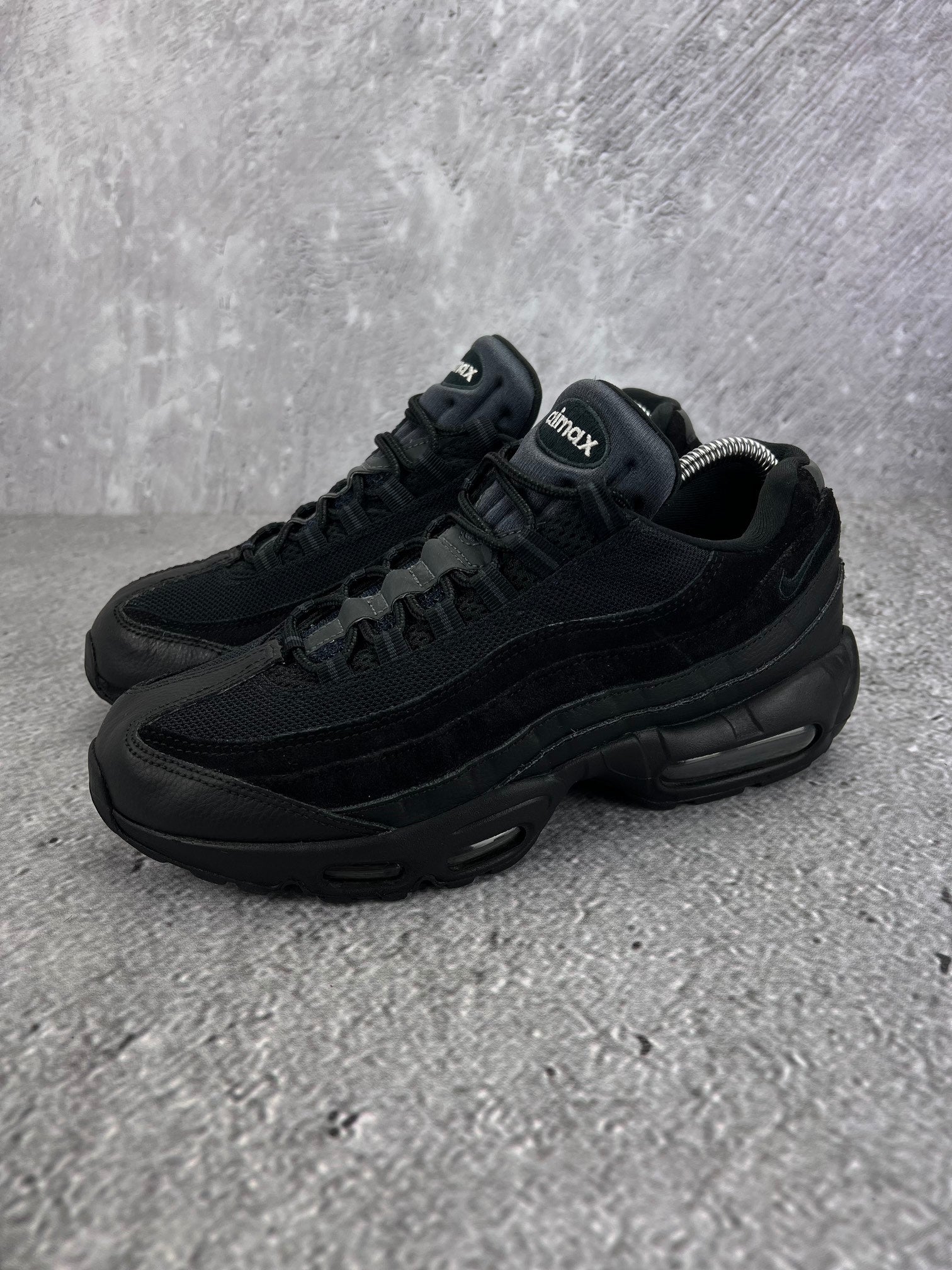 Nike Air Max 95 Essential Triple Black - buty sportowe, widok z boku na tle studyjnym