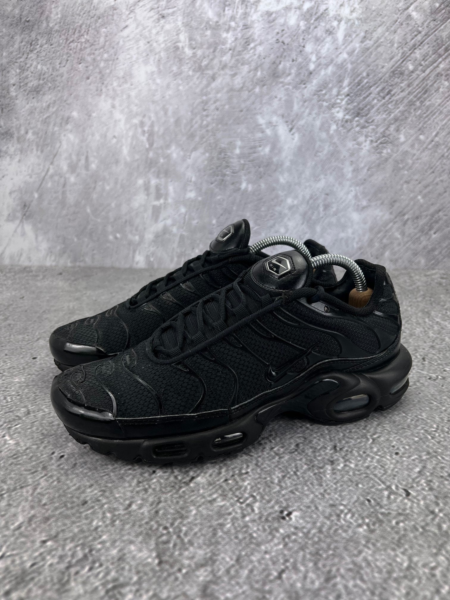 Nike Air Max Plus Triple Black - buty sportowe, widok z boku na tle studyjnym