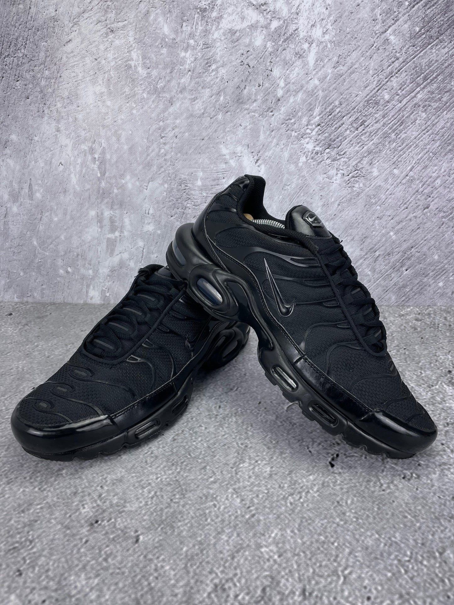 Nike Air Max Plus Triple Black - buty sportowe, para butów, widok z boku na tle studyjnym