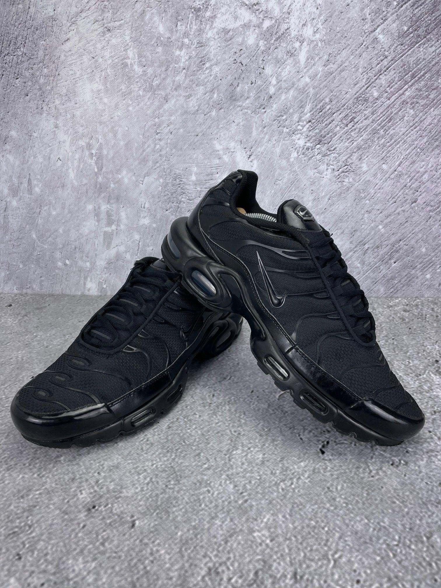 Nike Air Max Plus Triple Black - buty sportowe, para butów, widok z boku na tle studyjnym