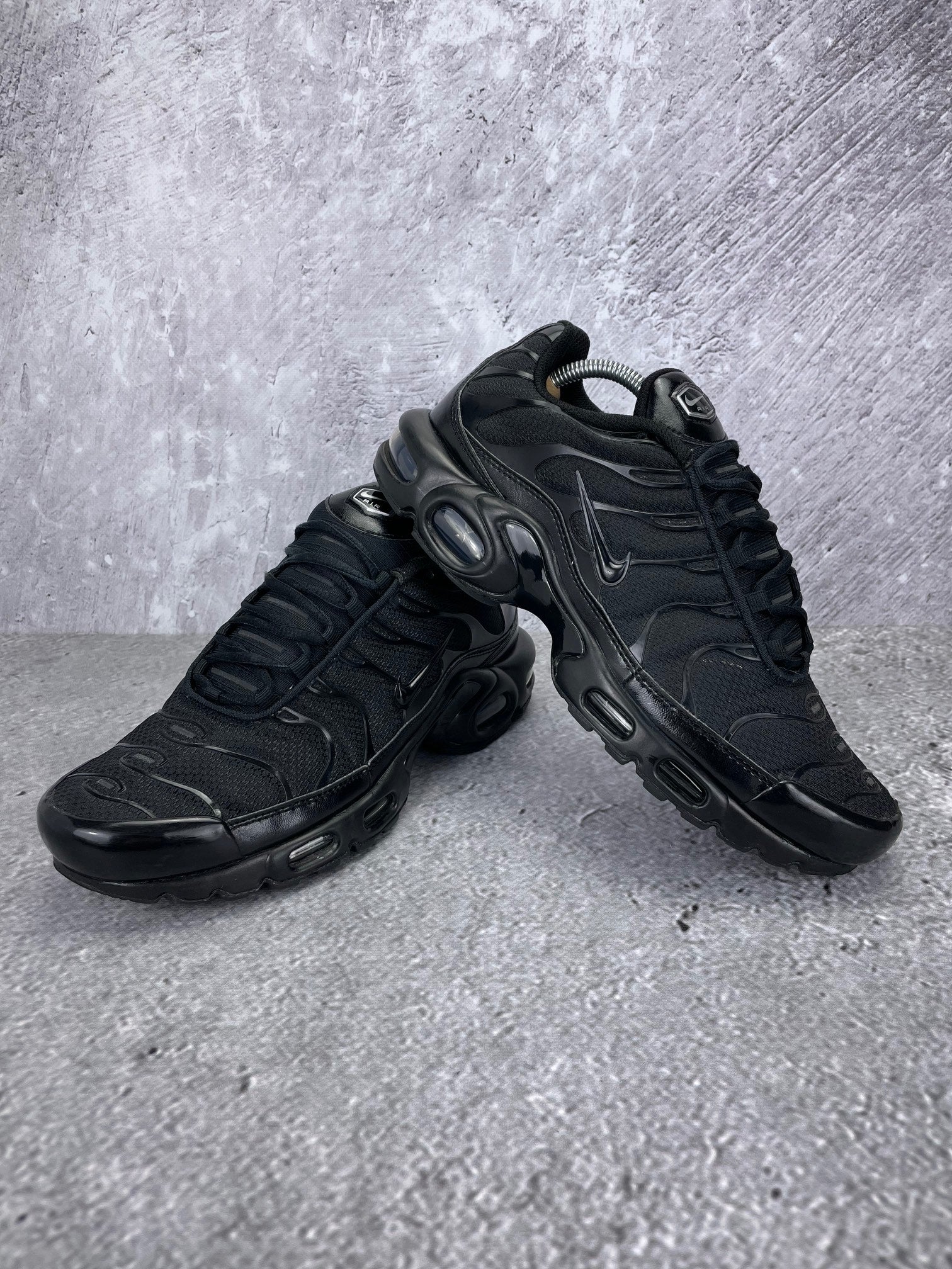 Nike Air Max Plus Triple Black - buty sportowe, para butów, widok z boku na tle studyjnym