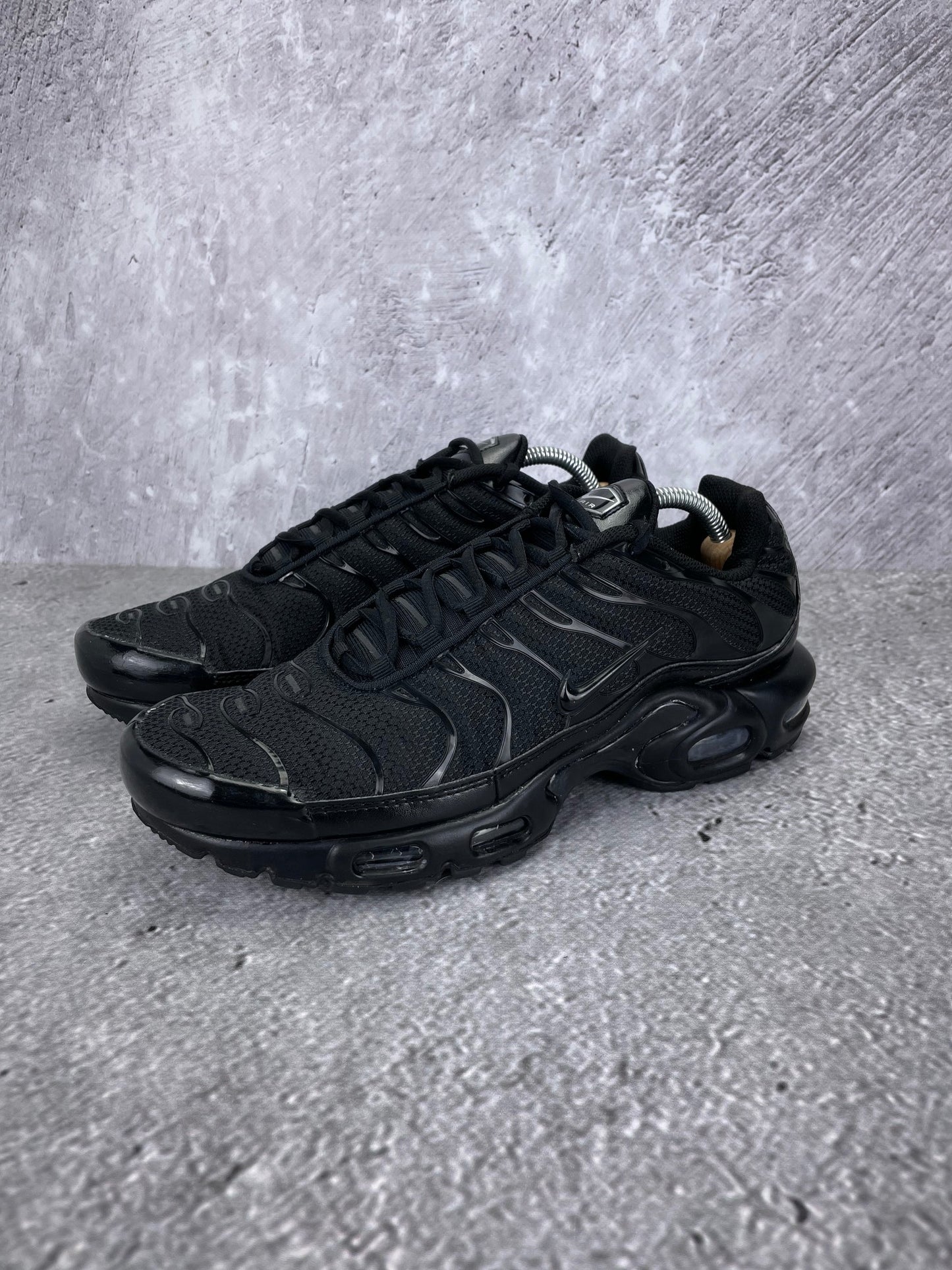 Nike Air Max Plus Triple Black - buty sportowe, widok z boku na tle studyjnym