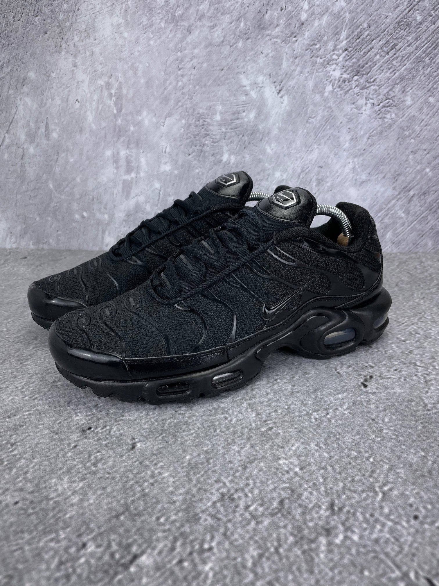 Nike Air Max Plus Triple Black - buty sportowe, widok z boku na tle studyjnym