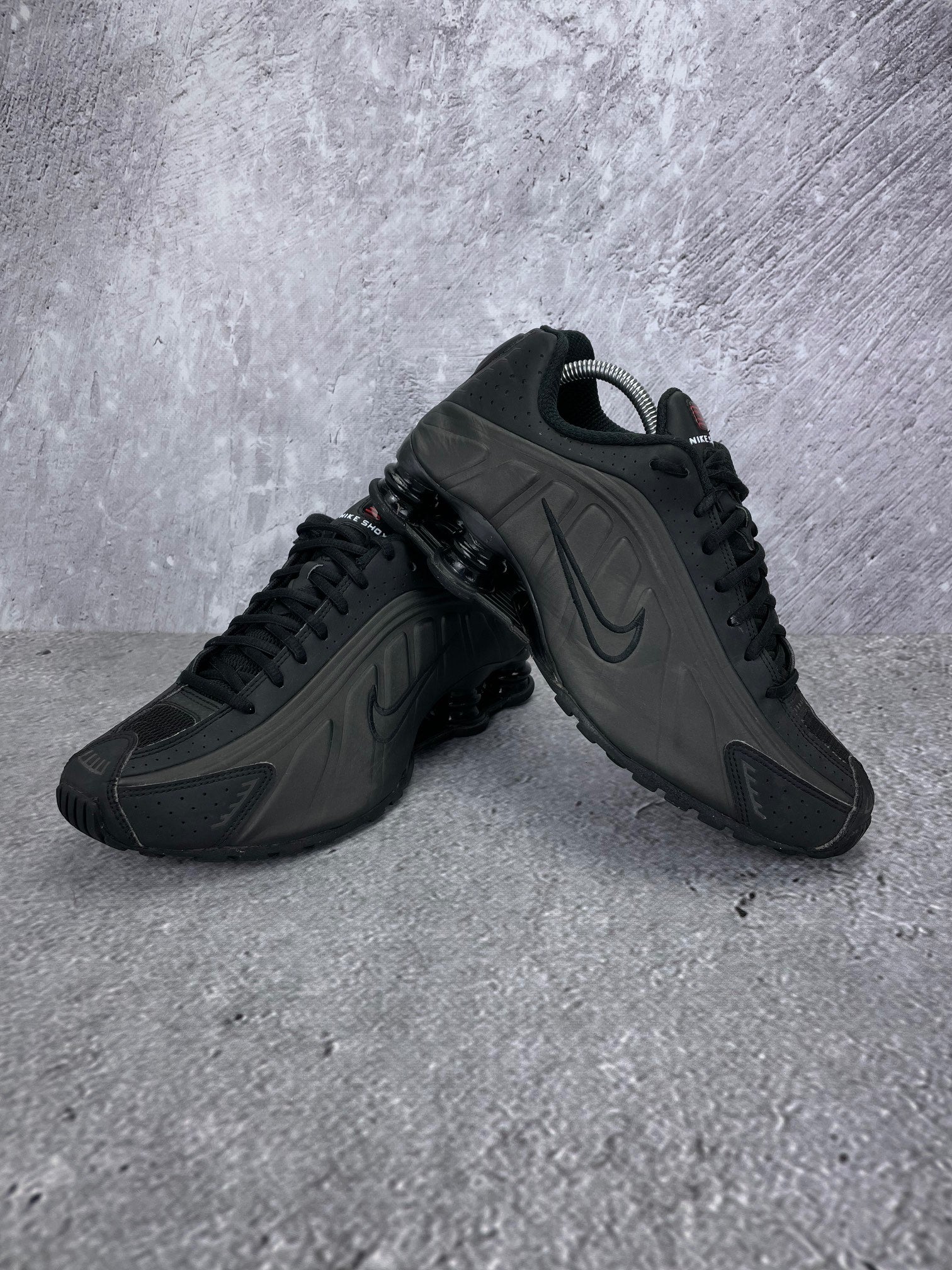Nike Shox R4 Triple Black - buty sportowe, para butów, widok z boku na tle studyjnym