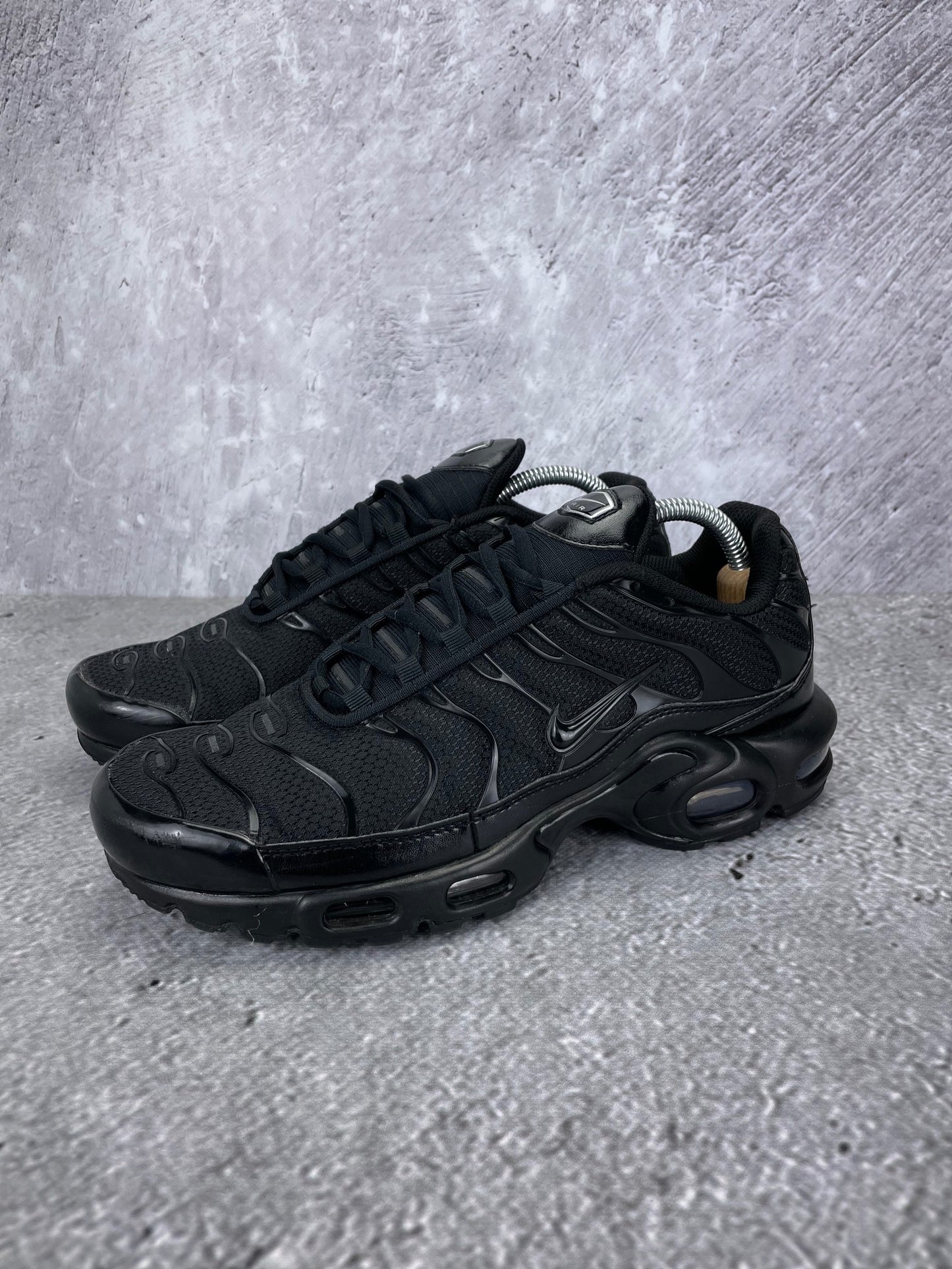 Nike Air Max Plus Triple Black - buty sportowe, widok z boku na tle studyjnym