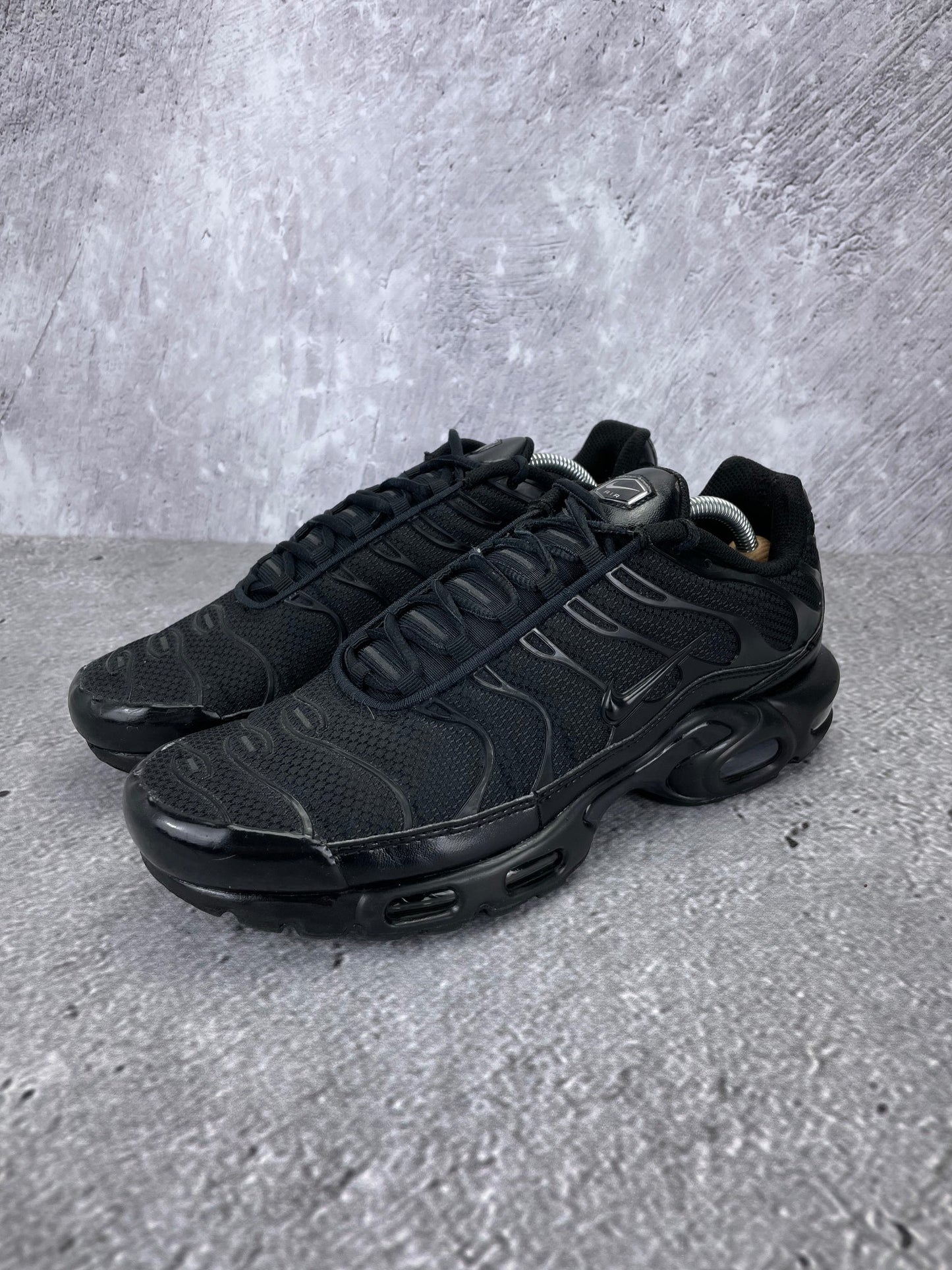 Nike Air Max Plus Triple Black - buty sportowe, widok z boku na tle studyjnym