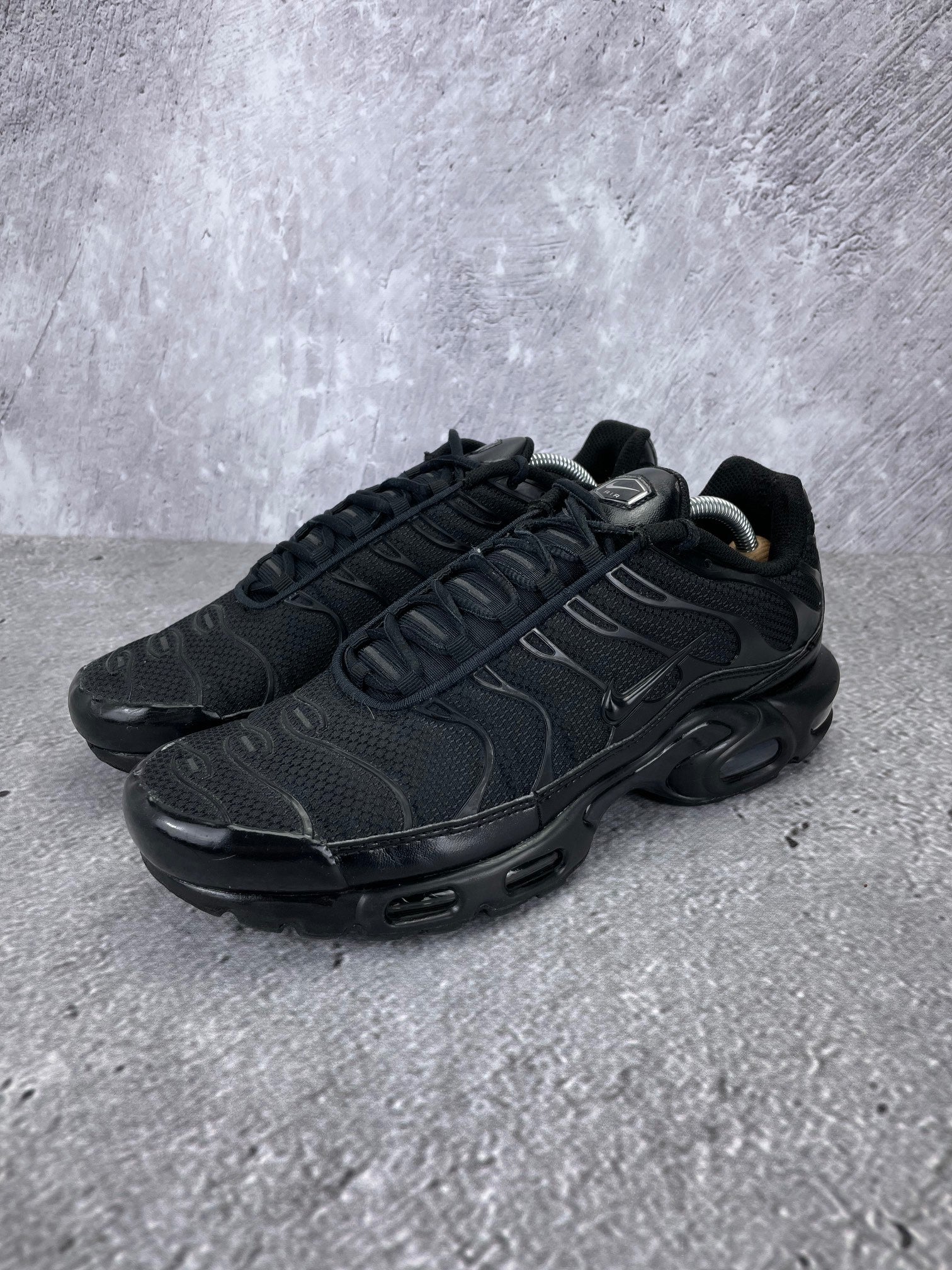 Nike Air Max Plus Triple Black - buty sportowe, widok z boku na tle studyjnym