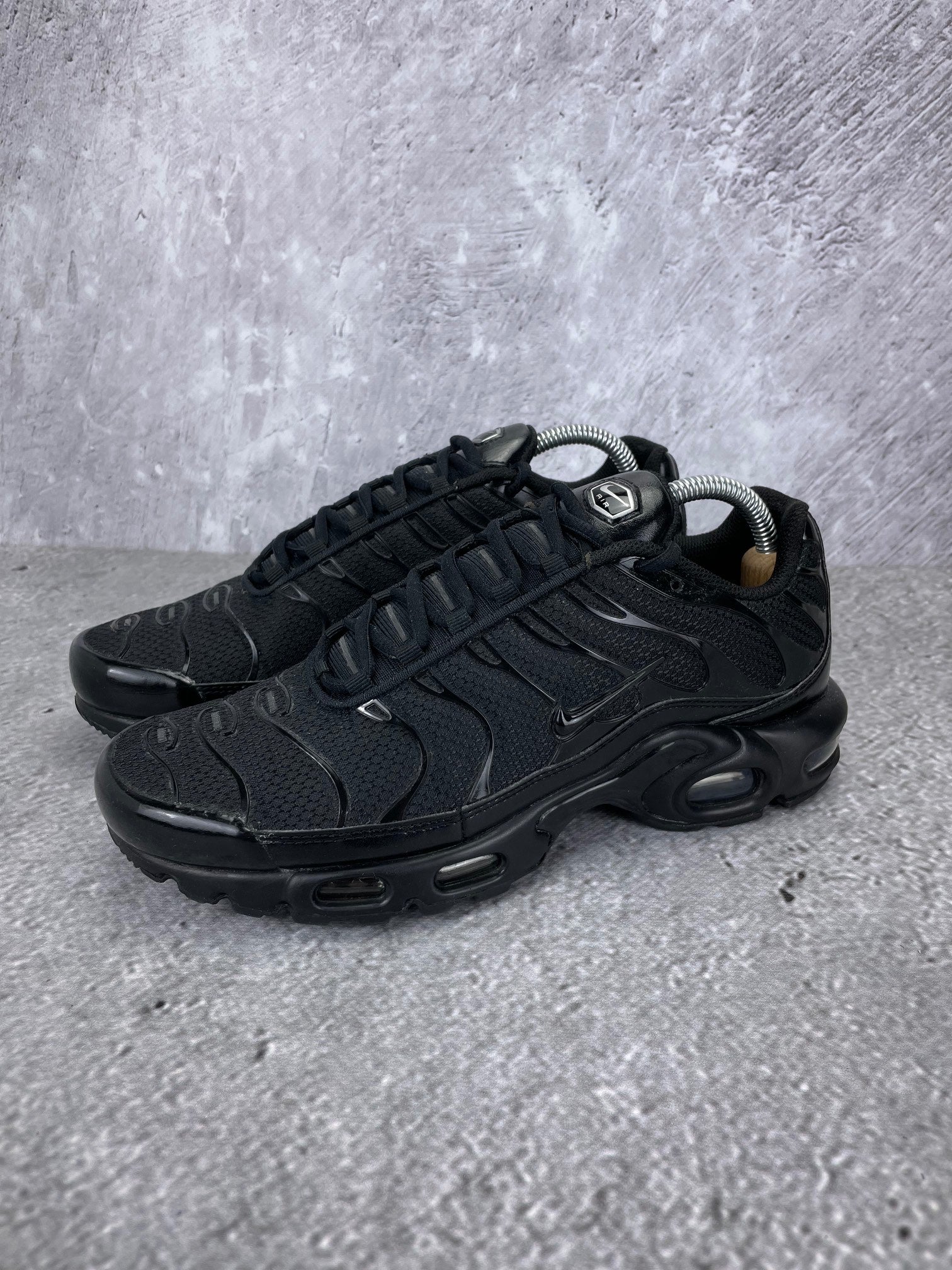 Nike Air Max Plus Triple Black - buty sportowe, widok z boku na tle studyjnym
