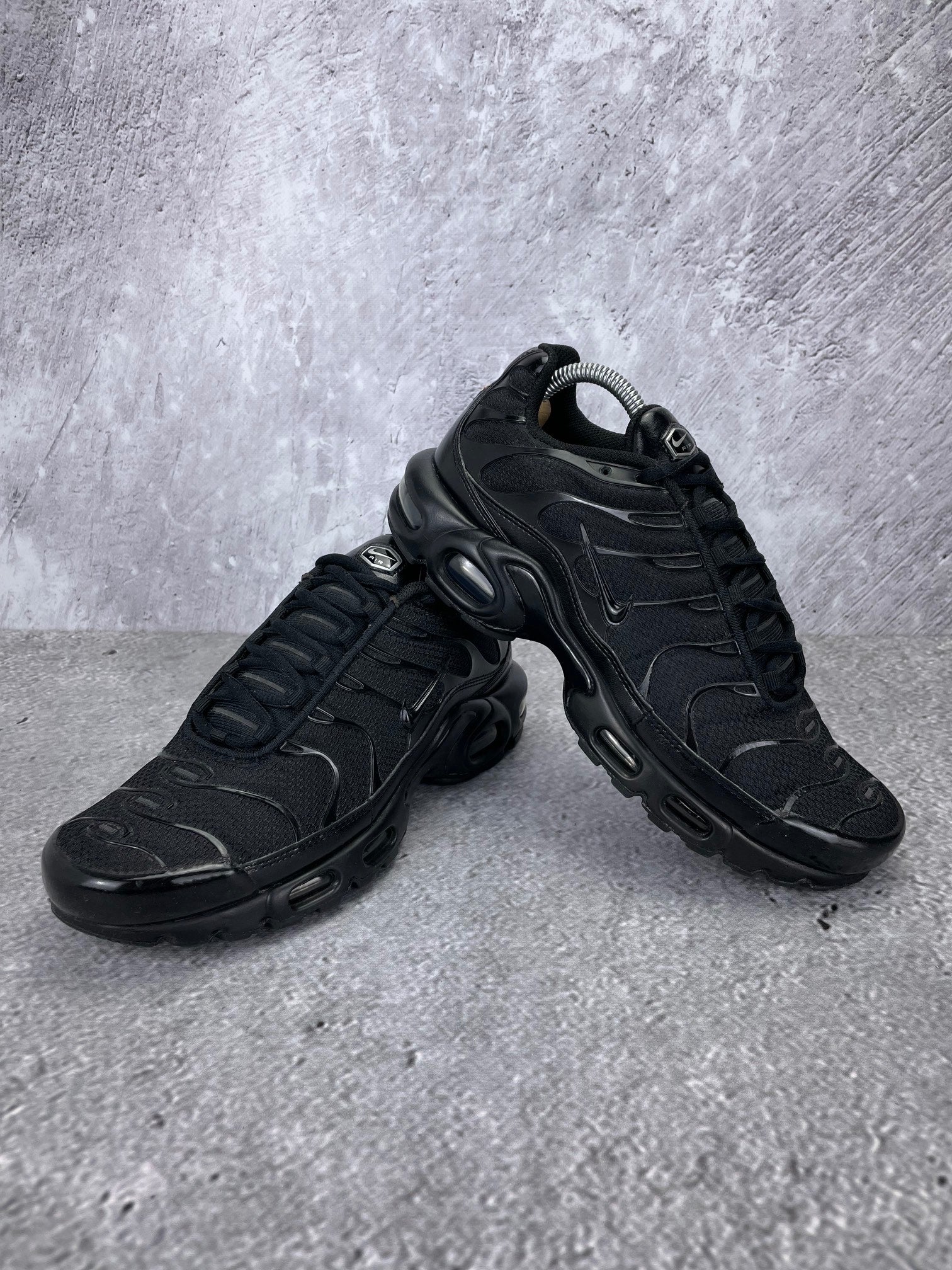 Nike Air Max Plus Triple Black - buty sportowe, para butów, widok z boku na tle studyjnym