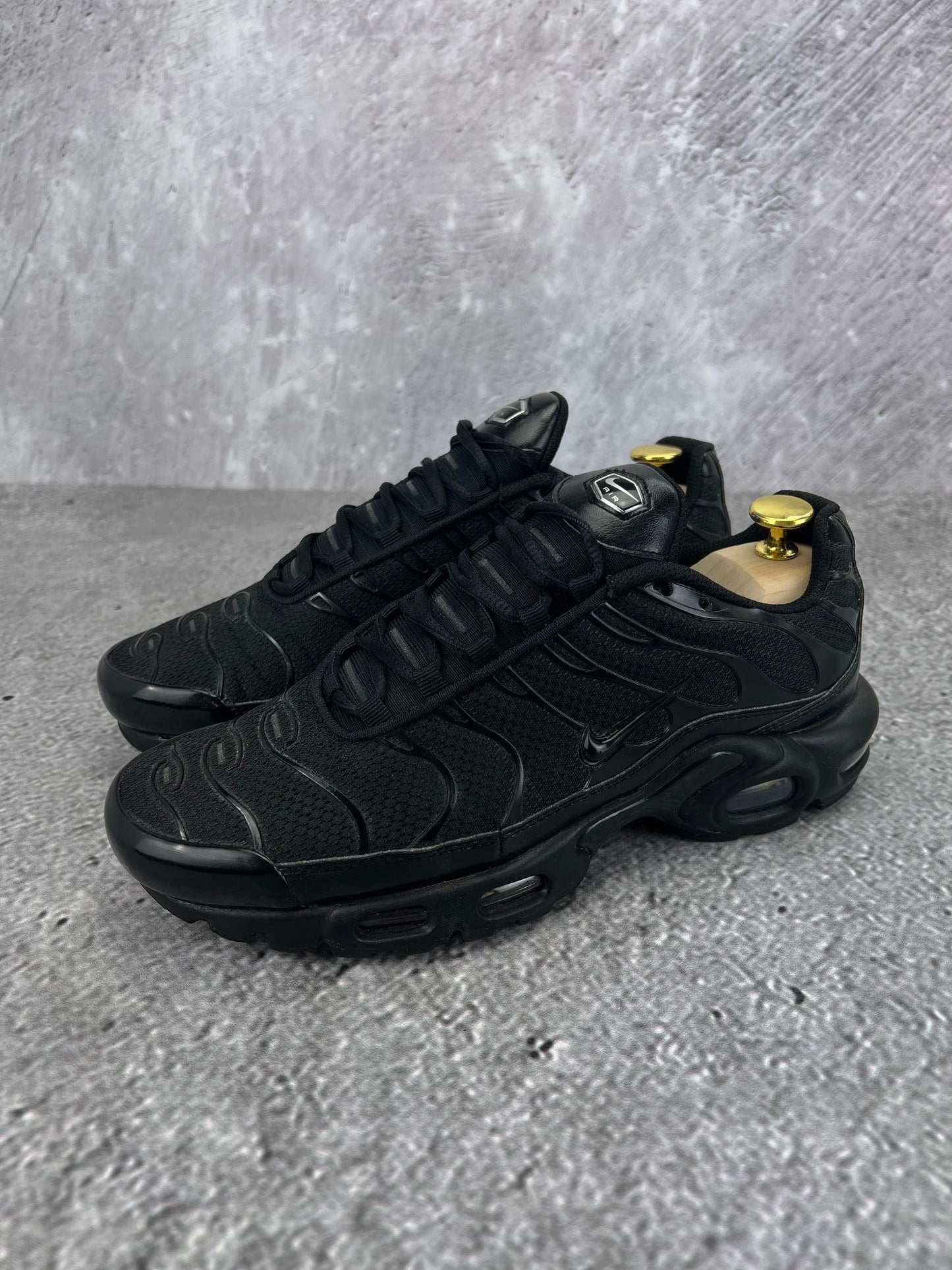 Nike Air Max Plus Triple Black - buty sportowe, widok z boku na tle studyjnym