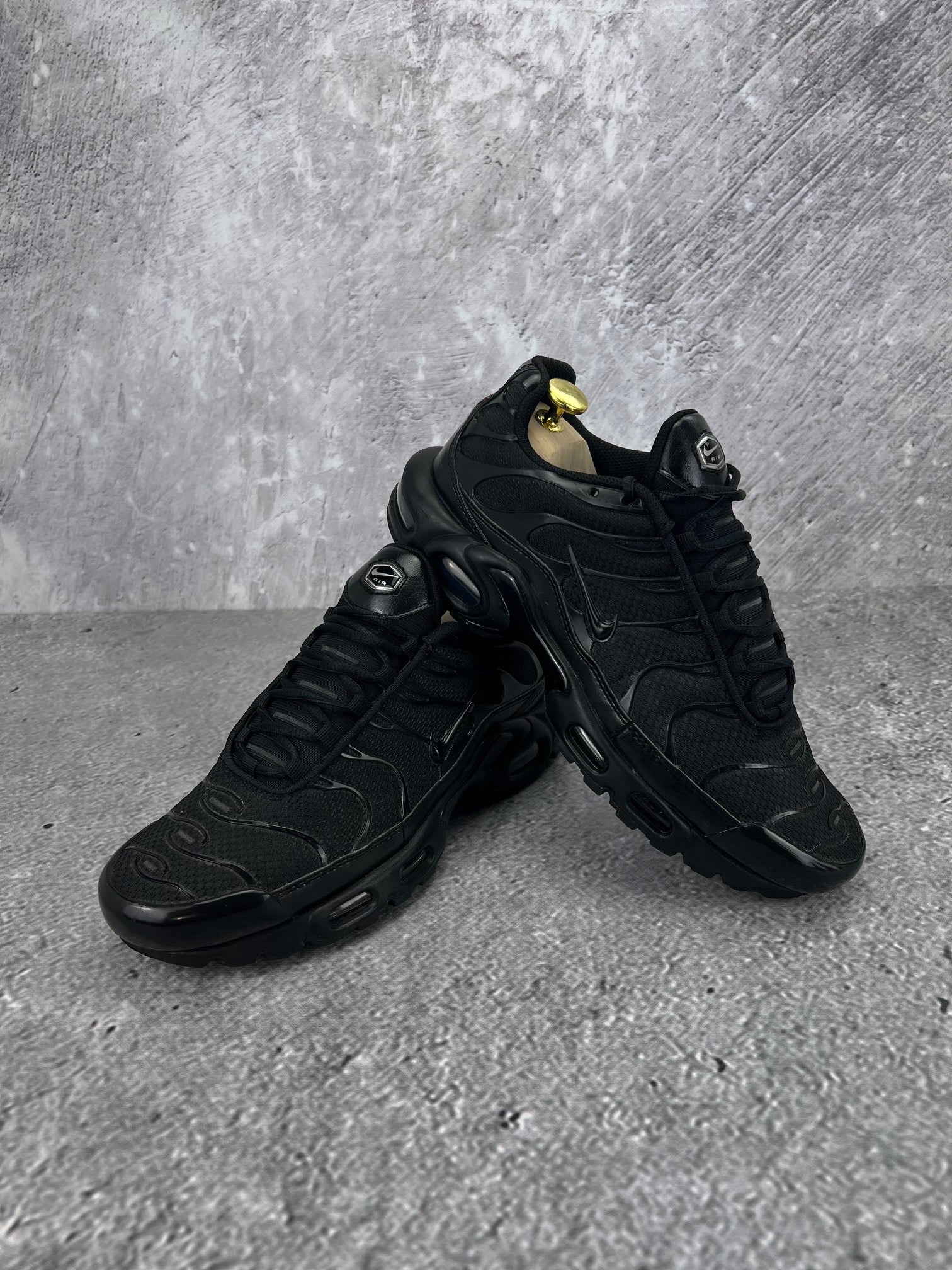 Nike Air Max Plus Triple Black - buty sportowe, para butów, widok z boku na tle studyjnym