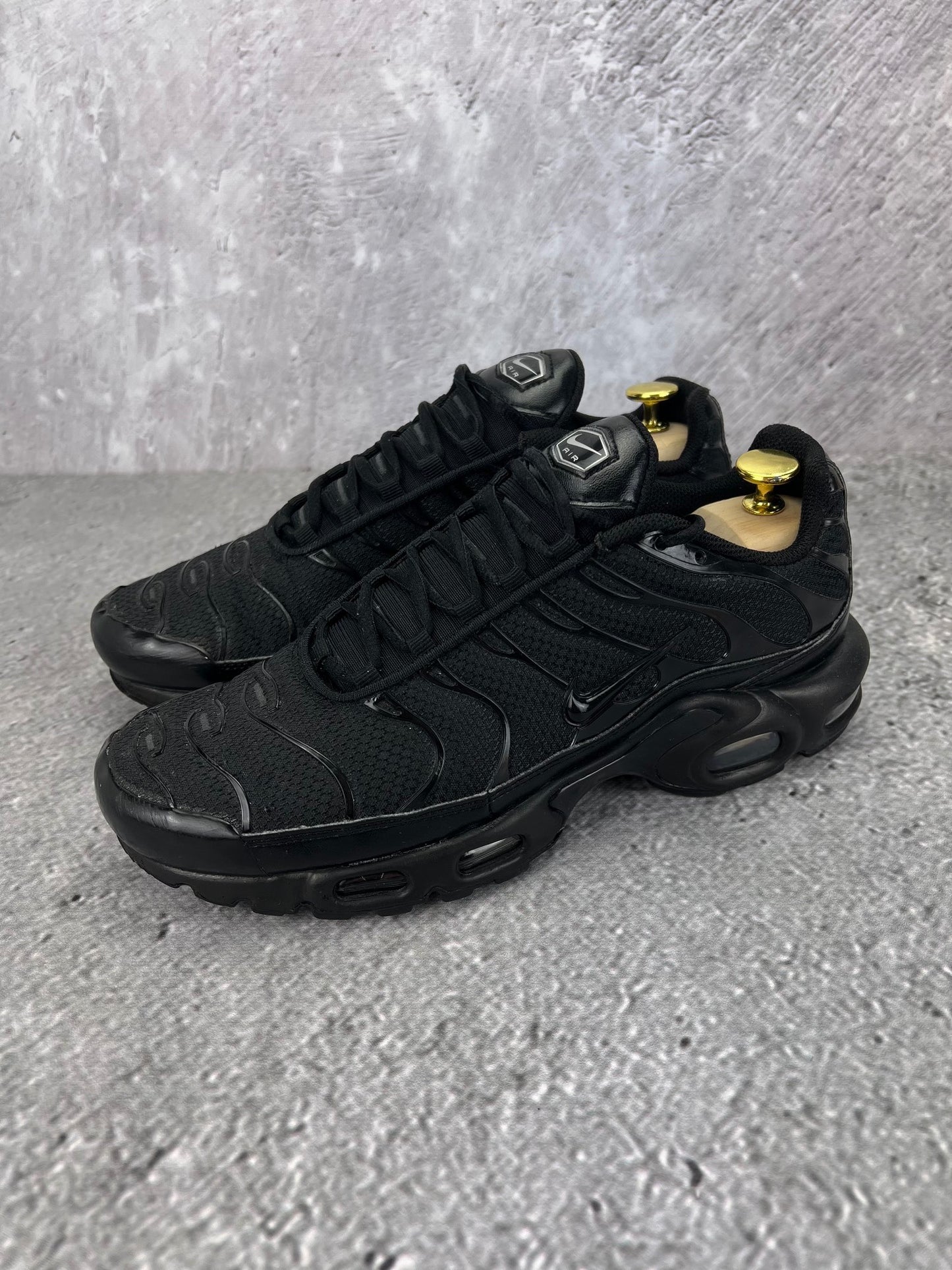 Nike Air Max Plus Triple Black - buty sportowe, widok z boku na tle studyjnym