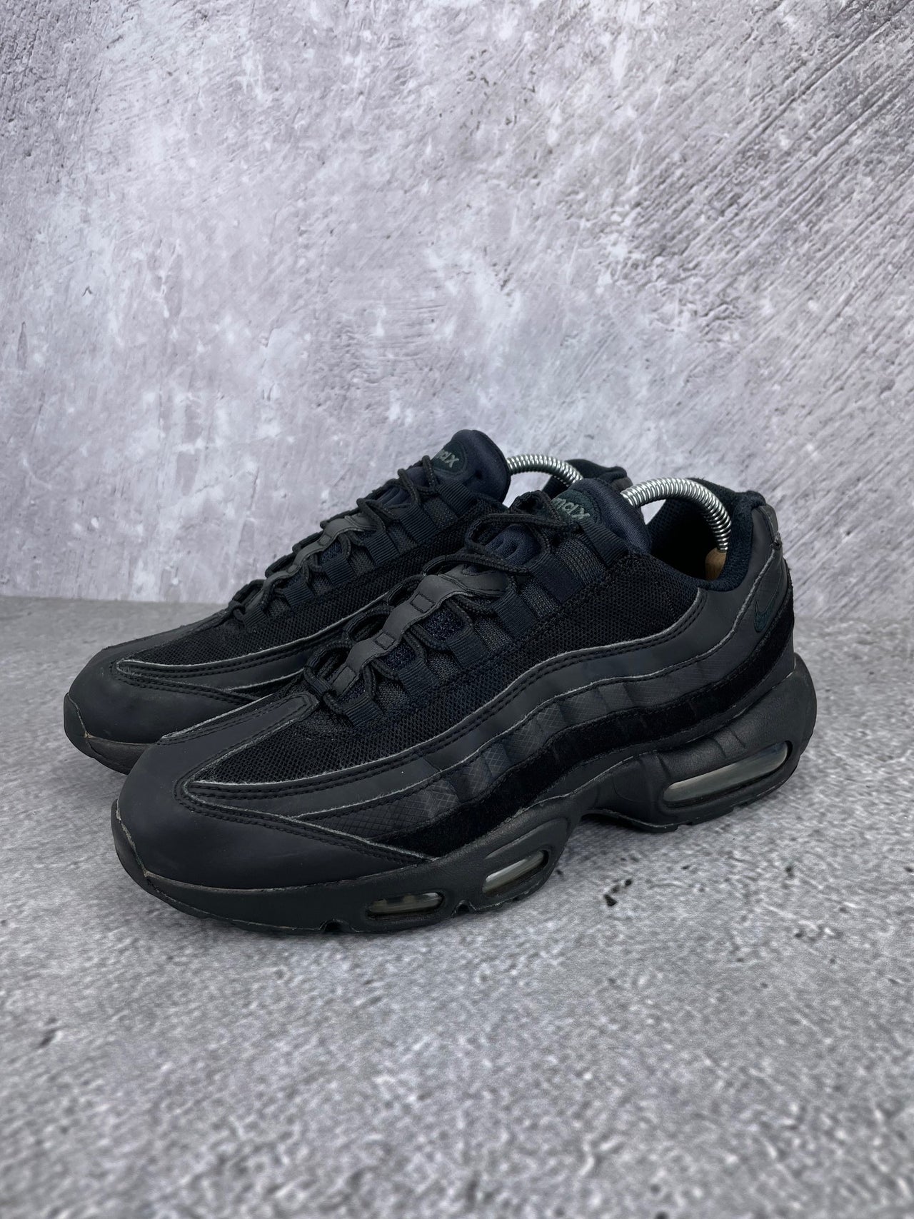 Nike Air Max 95 Essential Triple Black - buty sportowe, widok z boku na tle studyjnym