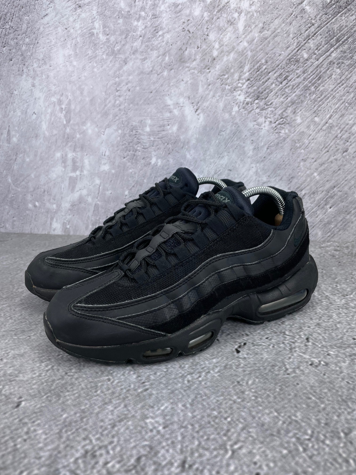 Nike Air Max 95 Essential Triple Black - buty sportowe, widok z boku na tle studyjnym