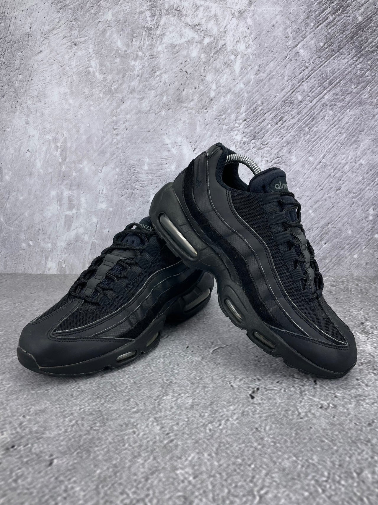 Nike Air Max 95 Essential Triple Black - buty sportowe, para butów, widok z boku na tle studyjnym