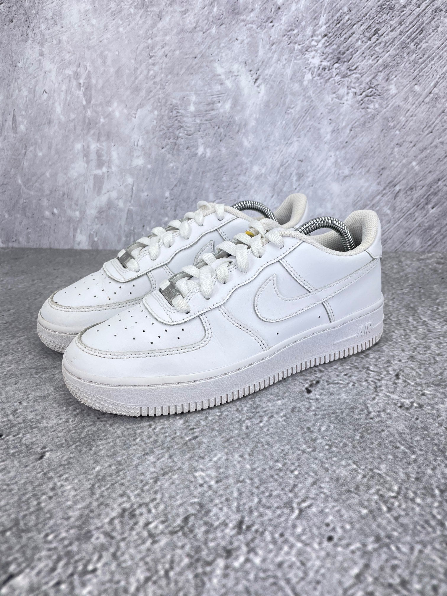 Nike Air Force 1 Low Triple White - buty sportowe, widok z boku na tle studyjnym