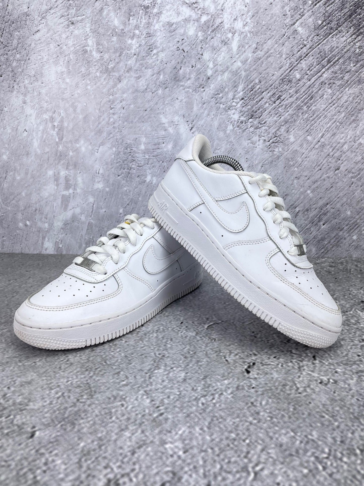 Nike Air Force 1 Low Triple White - buty sportowe, para butów, widok z boku na tle studyjnym
