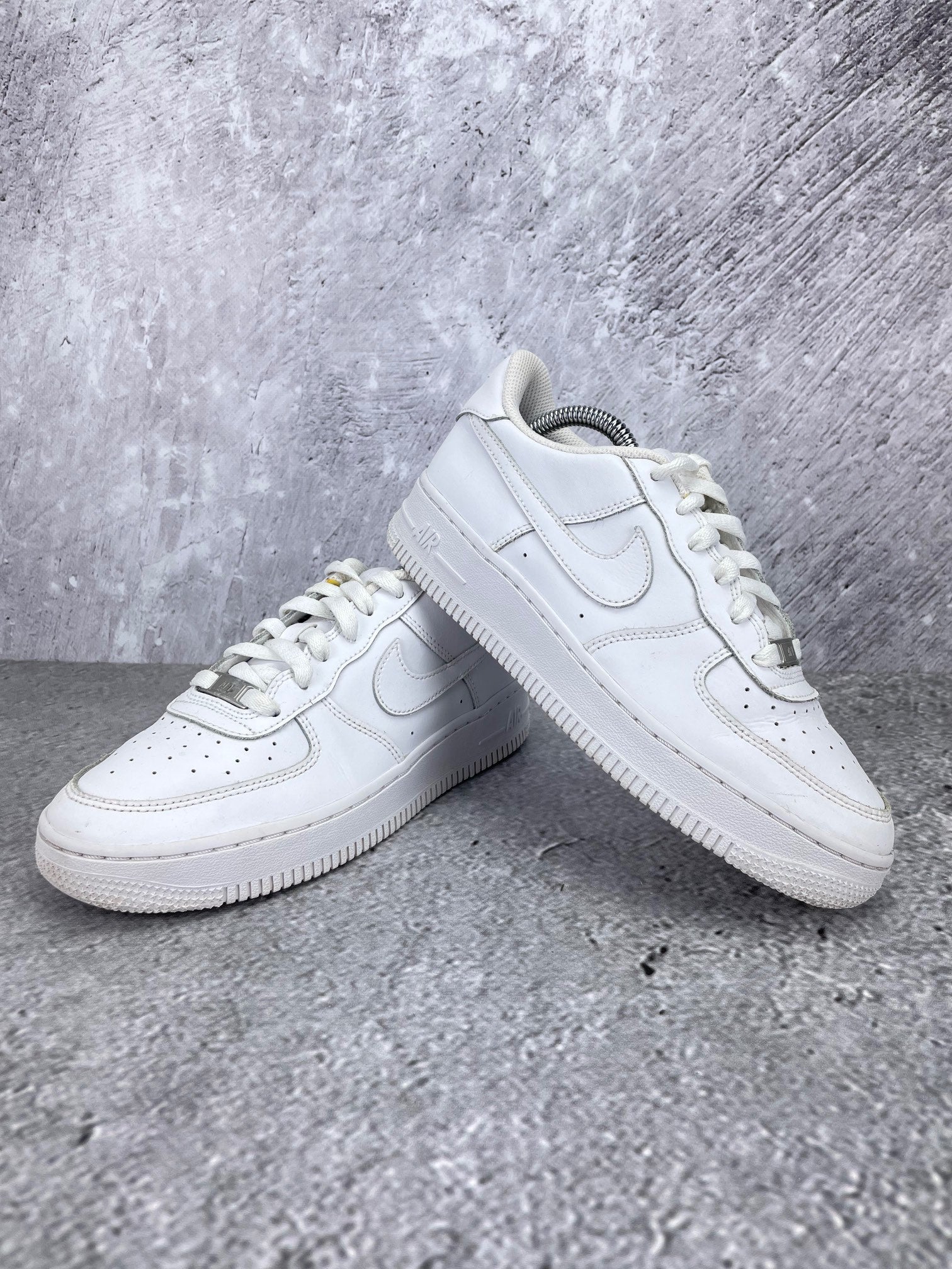 Nike Air Force 1 Low Triple White - buty sportowe, para butów, widok z boku na tle studyjnym