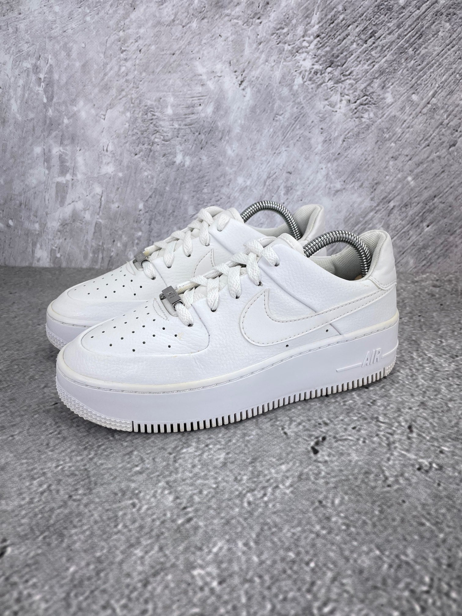 Nike Air Force 1 Sage Low Triple White - buty sportowe, widok z boku na tle studyjnym