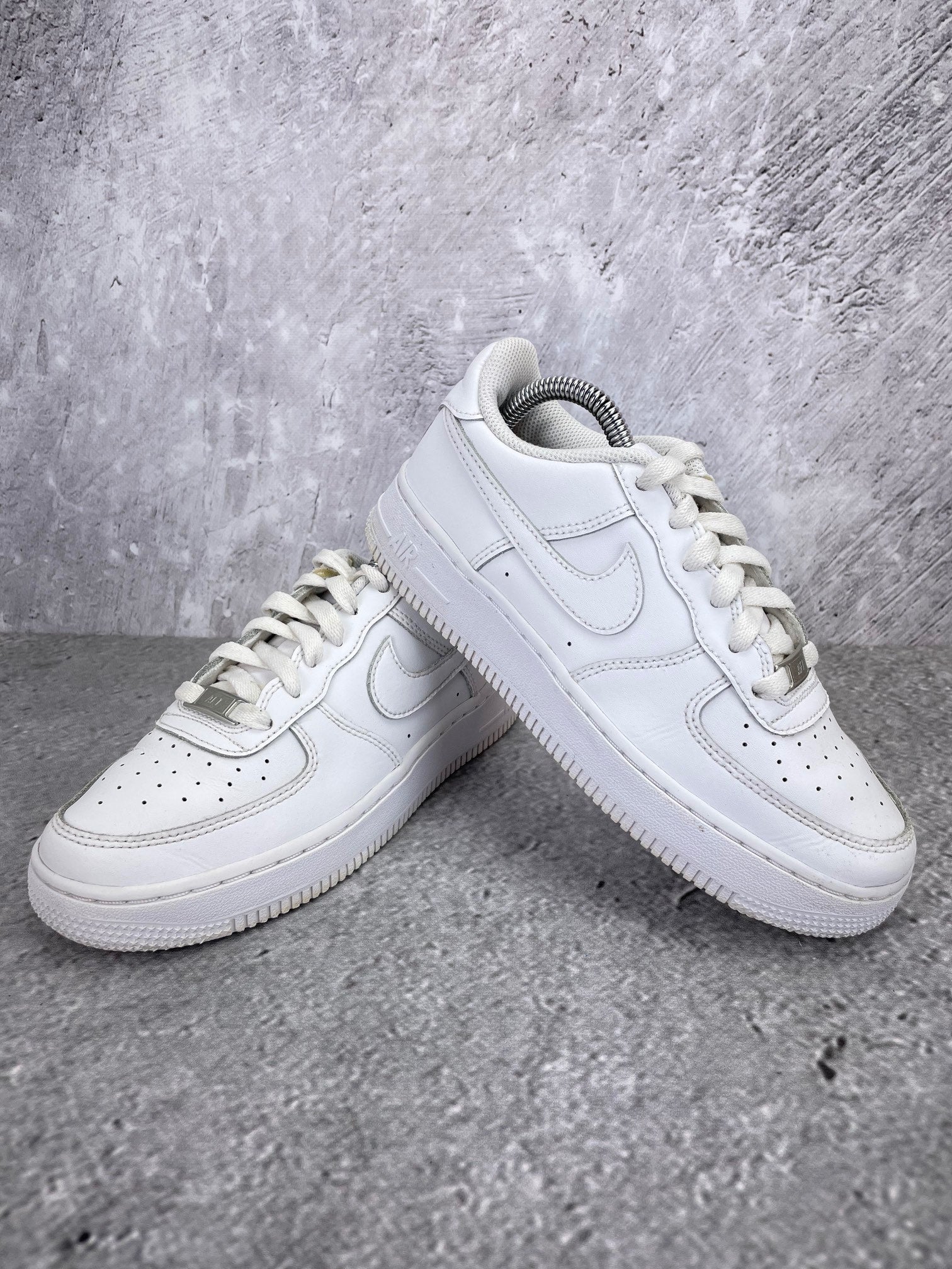 Nike Air Force 1 Low Triple White - buty sportowe, para butów, widok z boku na tle studyjnym