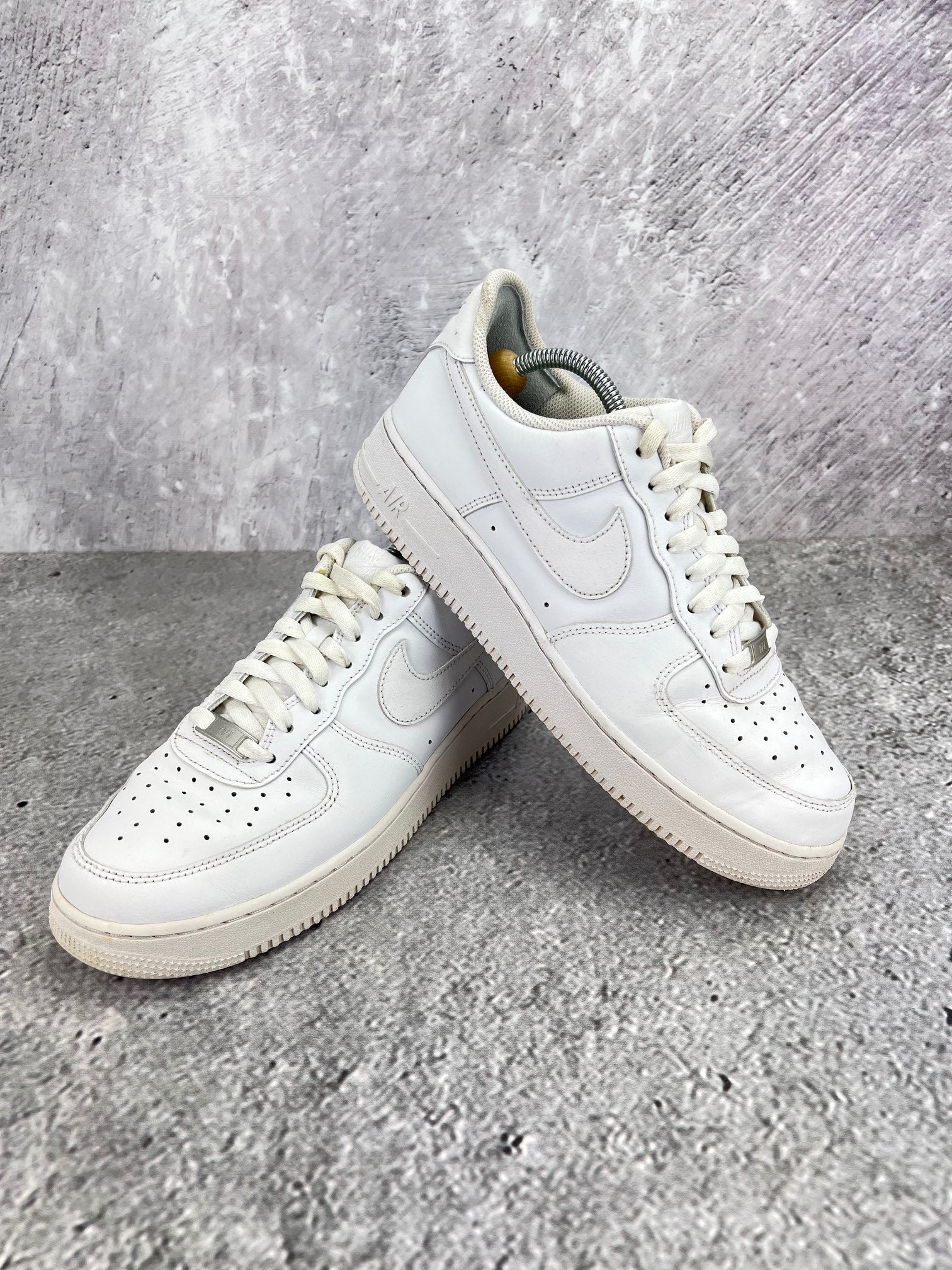 Nike Air Force 1 Low Triple White - buty sportowe, para butów, widok z boku na tle studyjnym