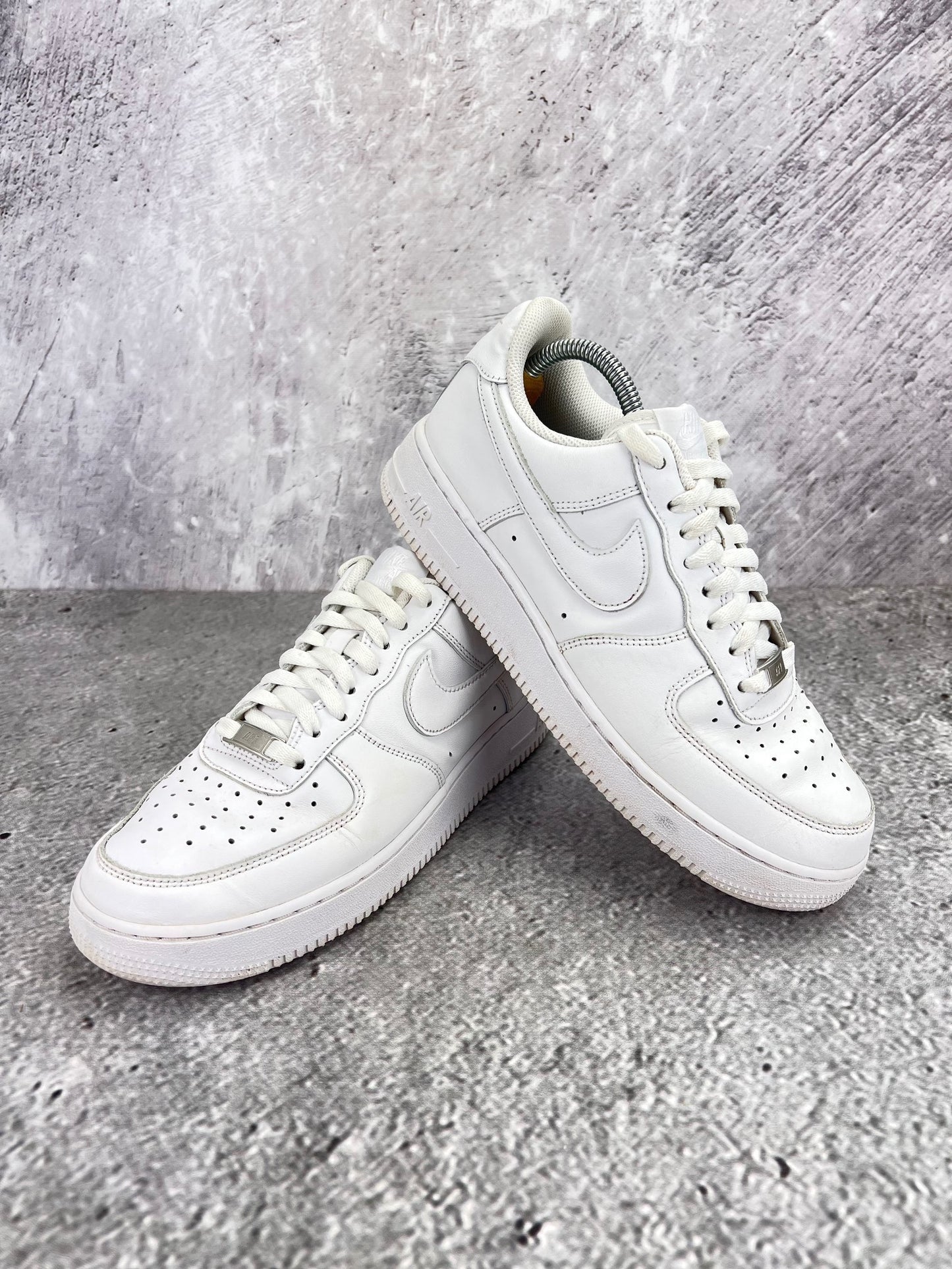 Nike Air Force 1 Low Triple White - buty sportowe, para butów, widok z boku na tle studyjnym