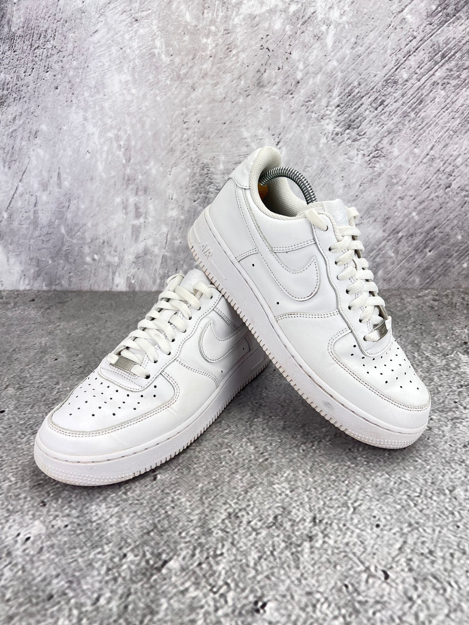 Nike Air Force 1 Low Triple White - buty sportowe, para butów, widok z boku na tle studyjnym