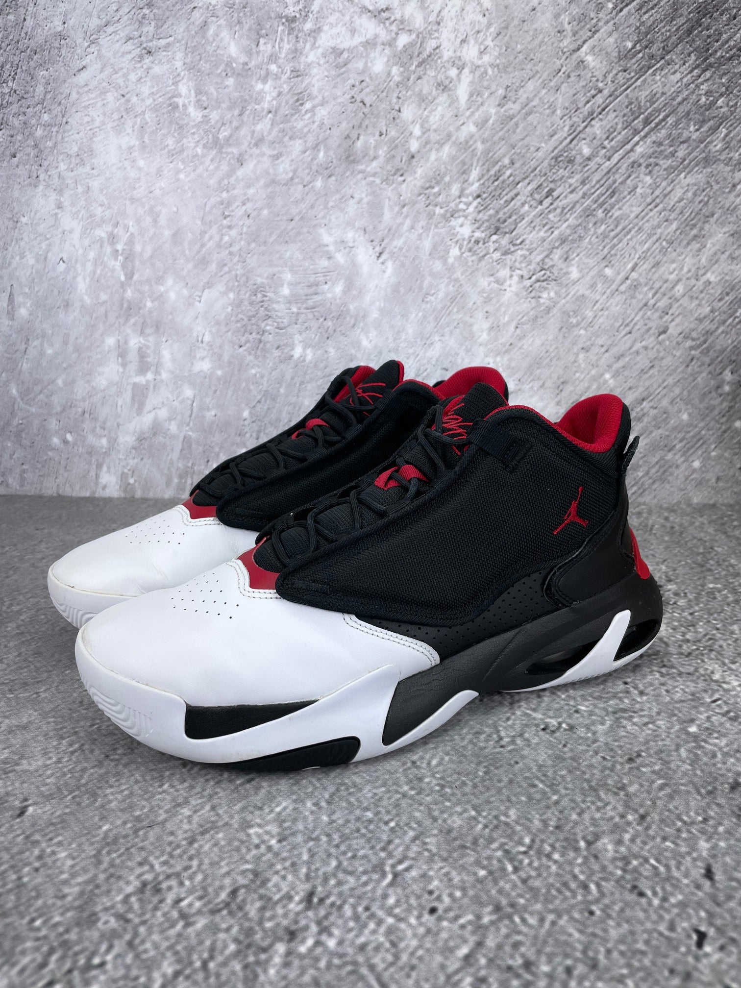 Jordan Max Aura 4 Black Gym Red - buty sportowe, widok z boku na tle studyjnym