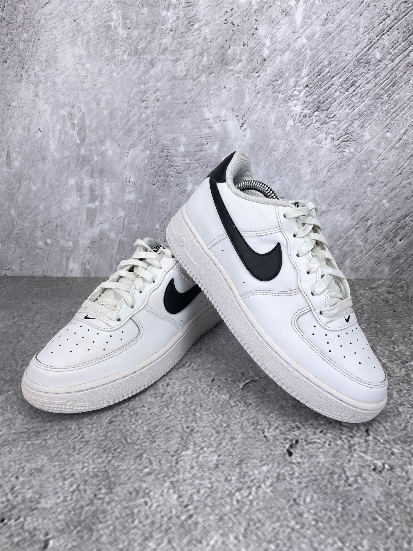 Nike Air Force 1 Low White Black - buty sportowe, para butów, widok z boku na tle studyjnym