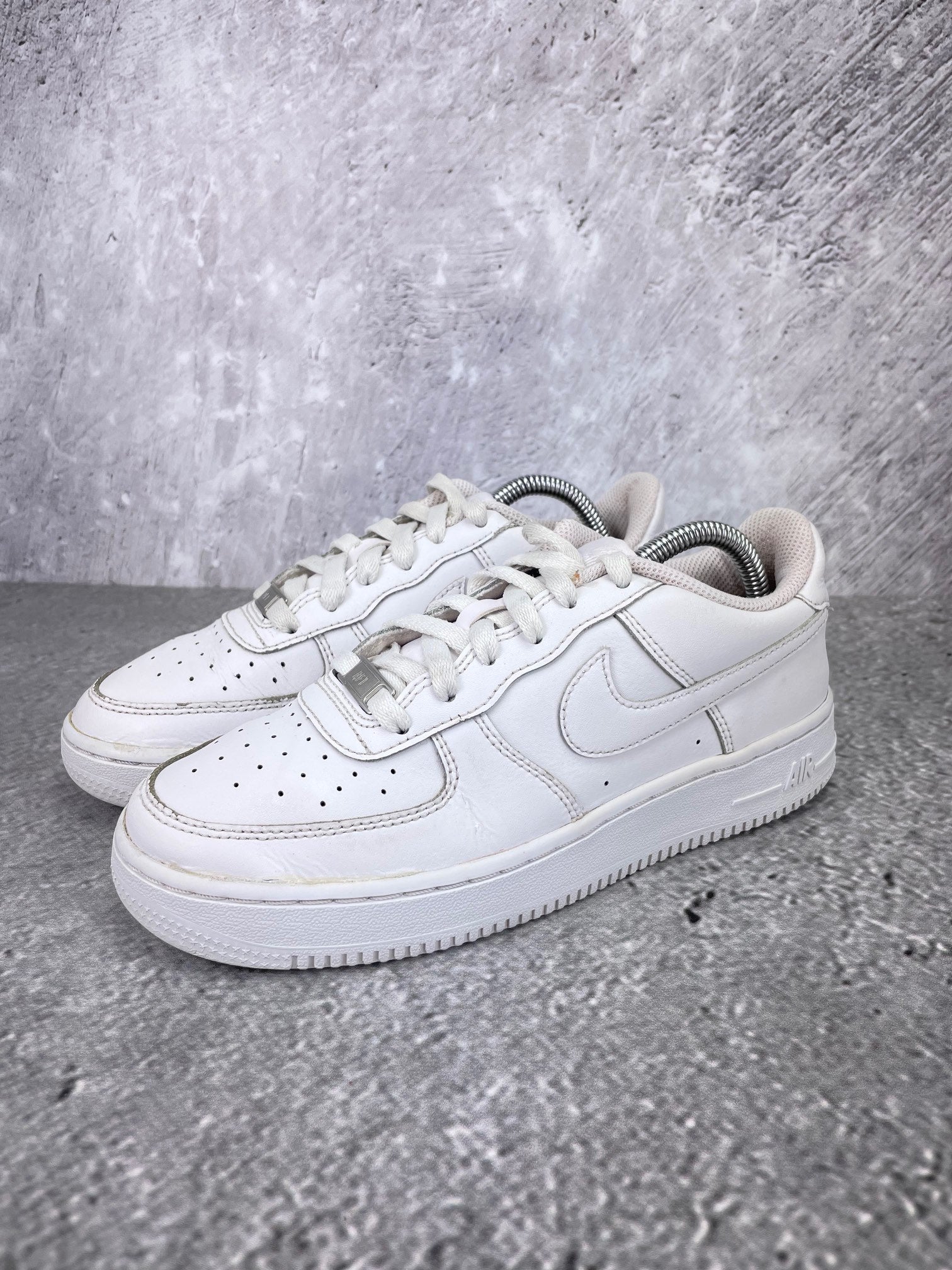 Nike Air Force 1 Low Triple White - buty sportowe, widok z boku na tle studyjnym