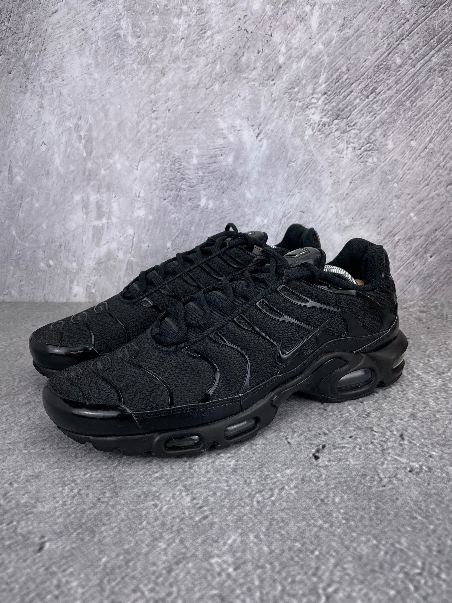 Nike Air Max Plus Triple Black - buty sportowe, widok z boku na tle studyjnym
