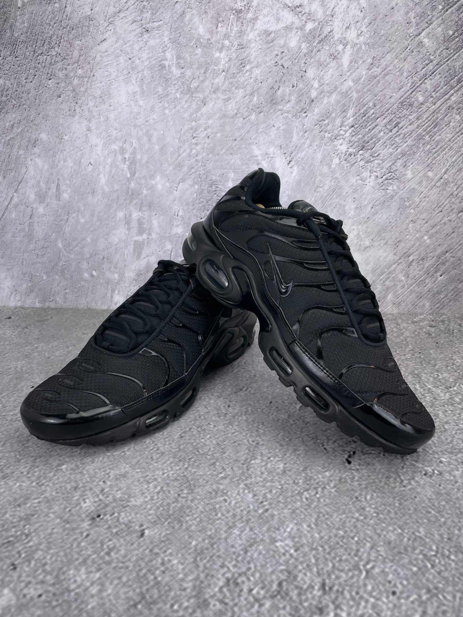 Nike Air Max Plus Triple Black - buty sportowe, para butów, widok z boku na tle studyjnym