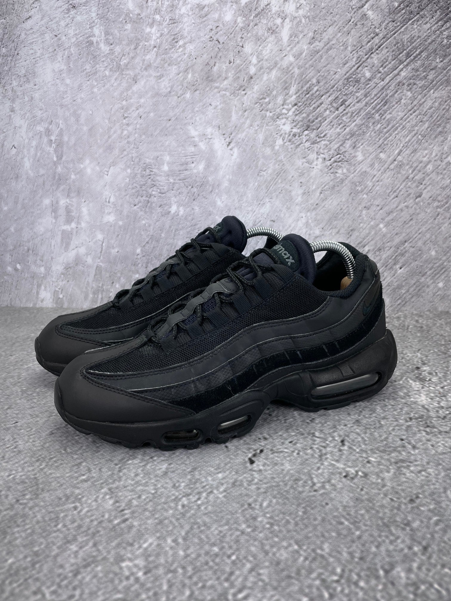 Nike Air Max 95 Essential Triple Black - buty sportowe, widok z boku na tle studyjnym